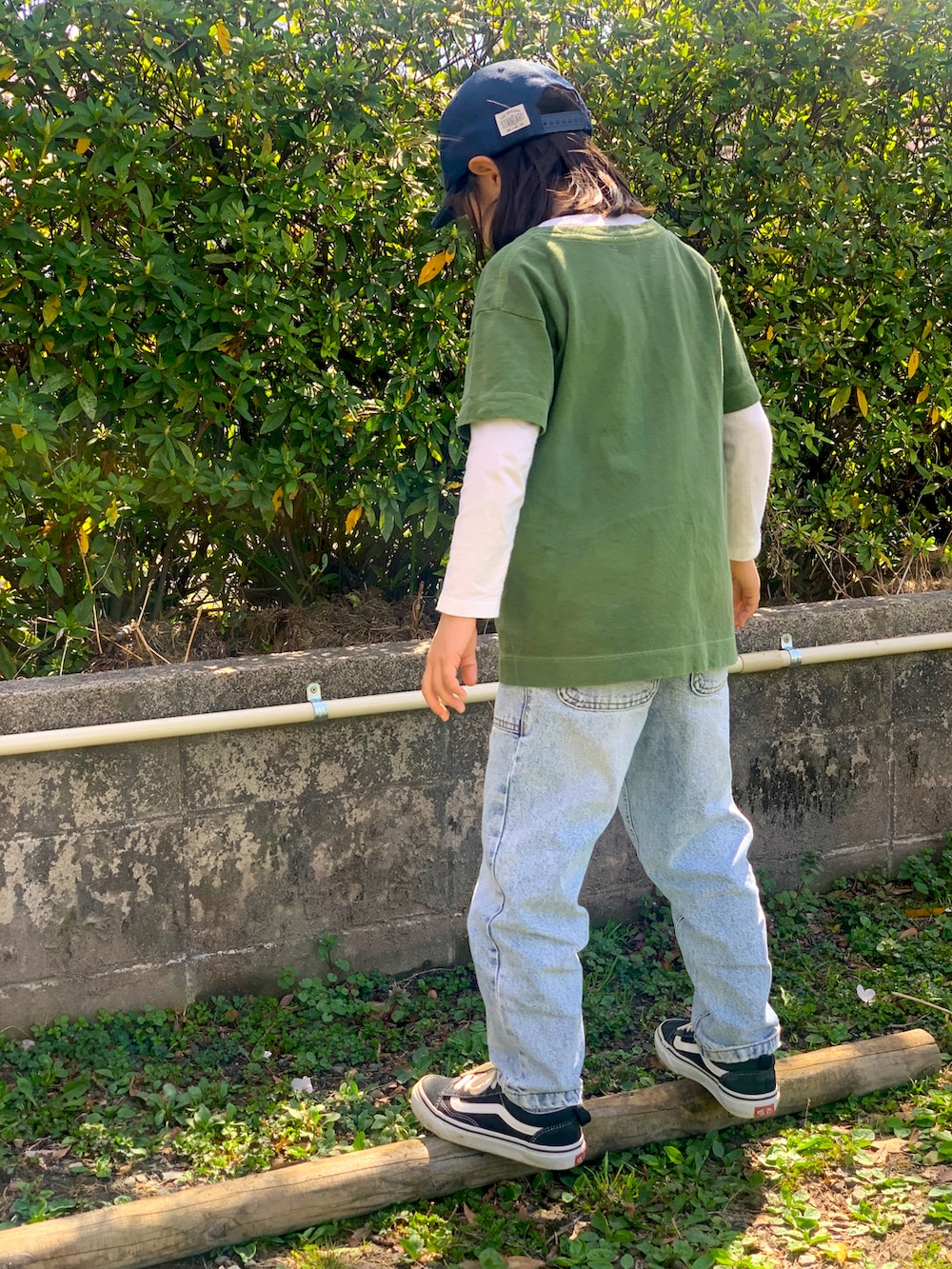 グリーン系のTシャツ/カットソー、ブルー系のデニムパンツ、ブラック系のスニーカーを着用したキッズの春コーディネートの2枚目の写真