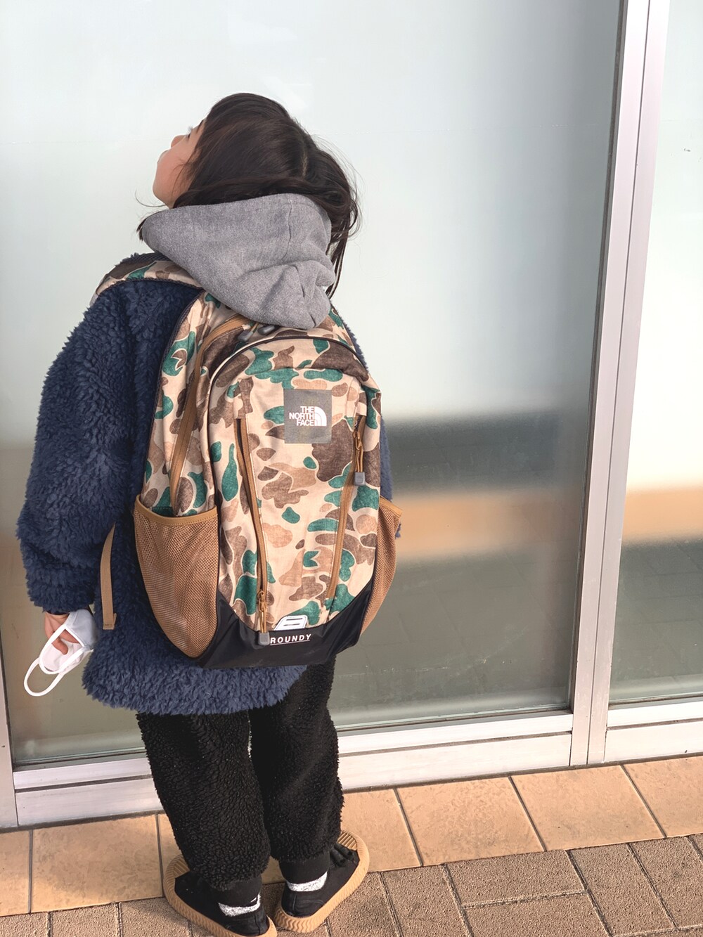 ブルー系のブルゾン、ブラック系のパンツ、ブラック系のスニーカーを着用したキッズの冬コーディネートの2枚目の写真