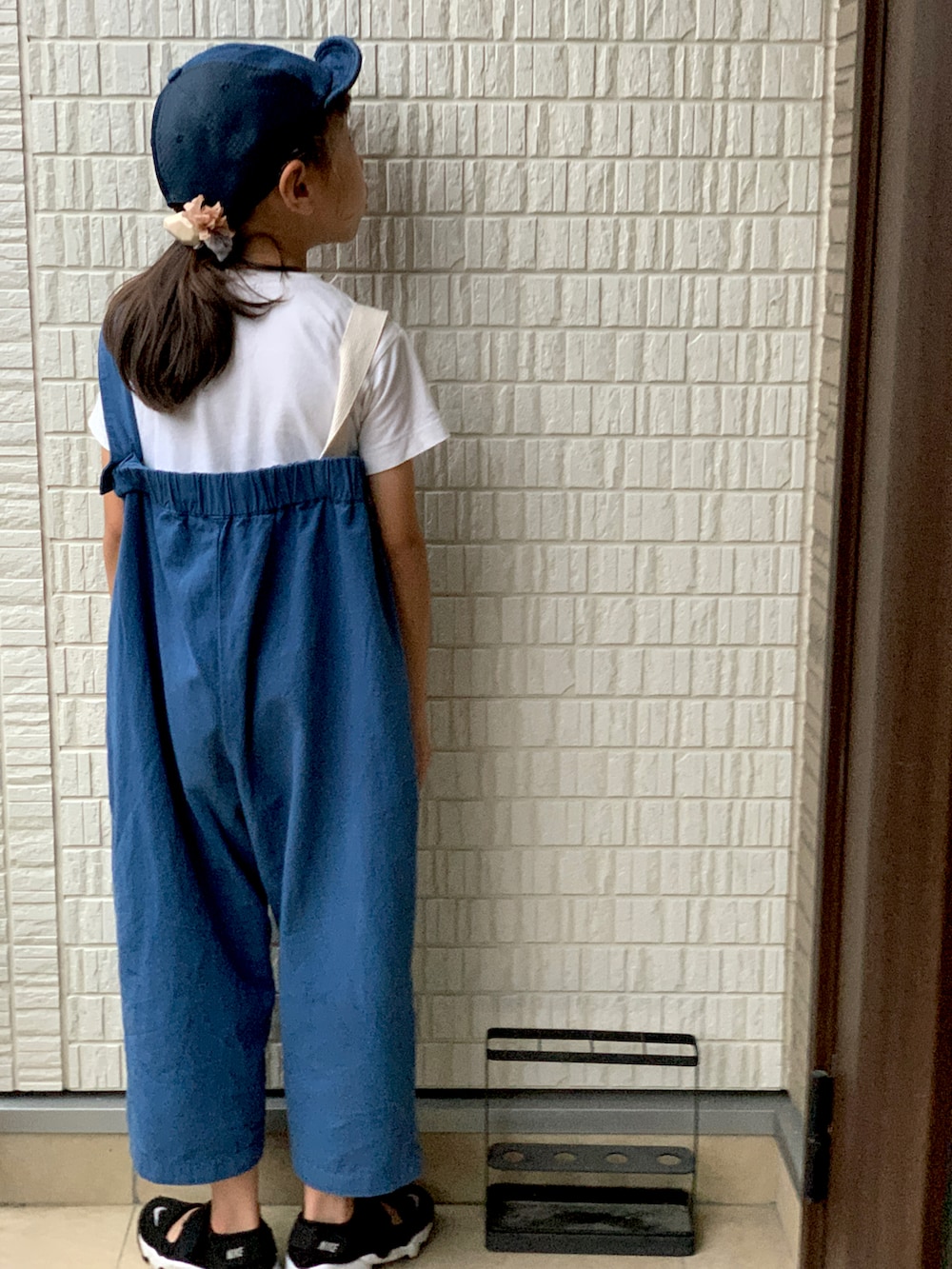 ブルー系のサロペット/オーバーオール、ブラック系のスニーカー、ホワイト系のTシャツ/カットソーを着用したキッズの夏コーディネートの2枚目の写真