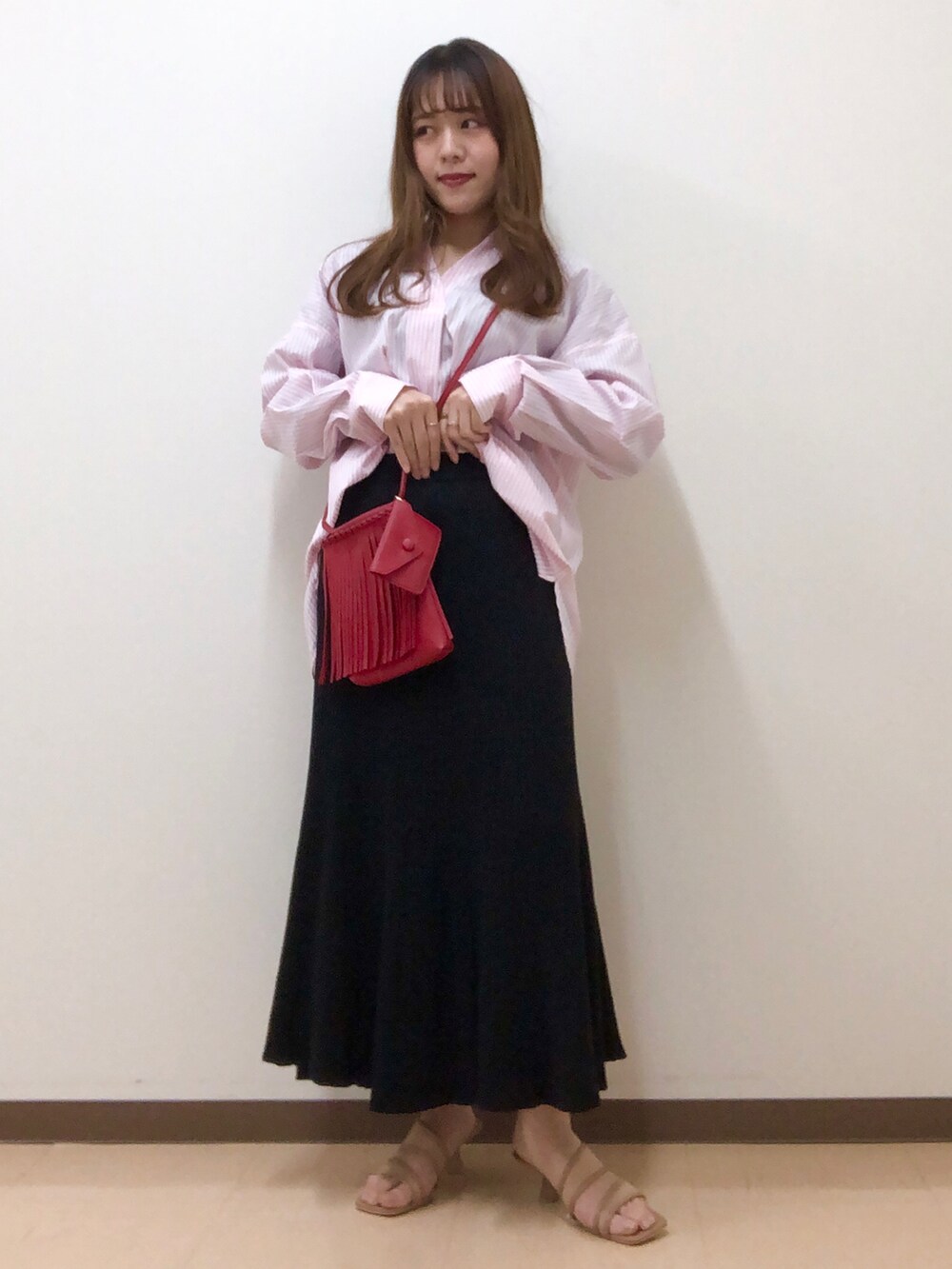 ピンク系のシャツ/ブラウス、ブラック系のスカート、ブラウン系のサンダルを着用したレディースの春コーディネートの2枚目の写真