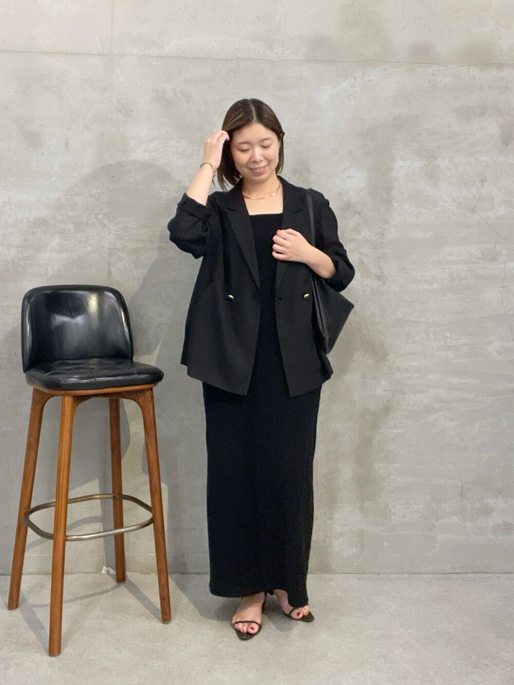 ブラック系のワンピース、ブラック系のテーラードジャケット、ブラック系のショルダーバッグを着用したレディースの夏コーディネートの5枚目の写真