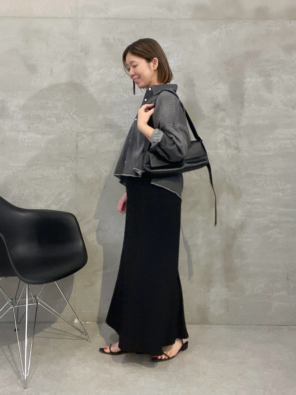 ブラック系のスカート、ブラック系のシャツ/ブラウス、ホワイト系のショルダーバッグを着用したレディースの夏コーディネートの2枚目の写真