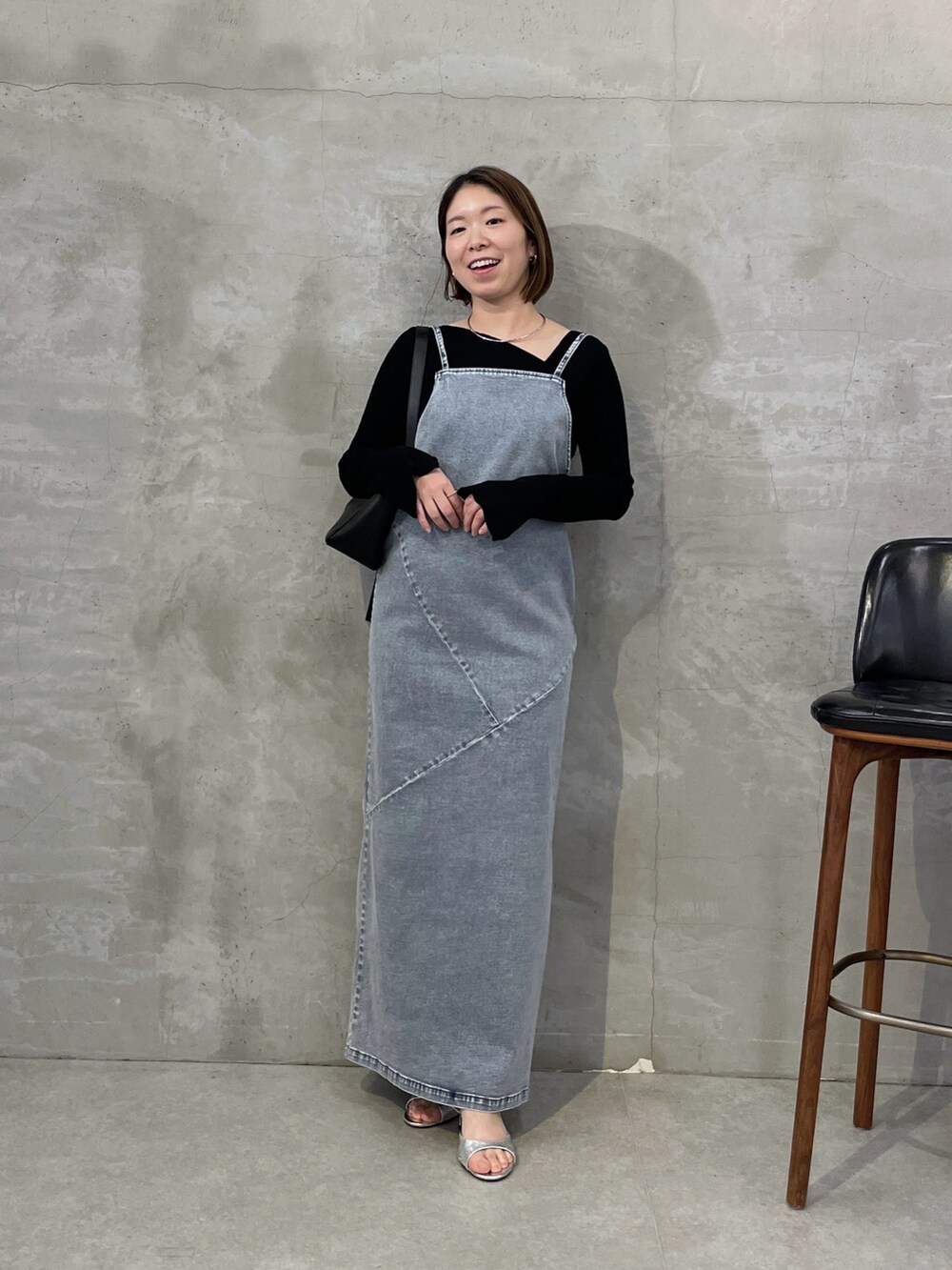 ブルー系のワンピース、ブラック系のニット/セーター、シルバー系のネックレスを着用したレディースの冬コーディネートの5枚目の写真