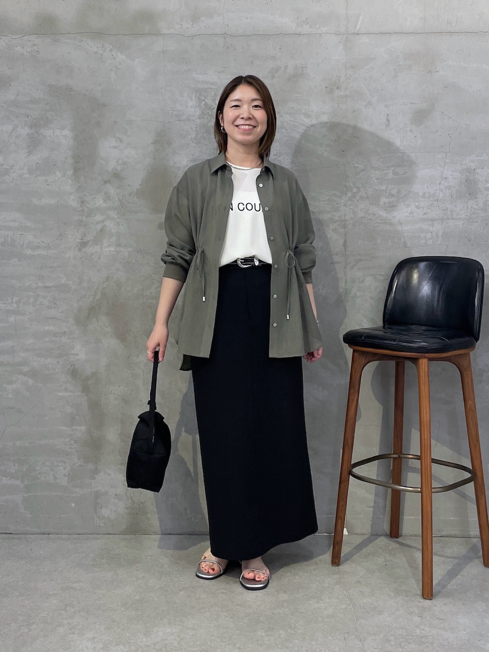 グリーン系のシャツ/ブラウス、ホワイト系のTシャツ/カットソー、ブラック系のスカートを着用したレディースの春コーディネートの5枚目の写真