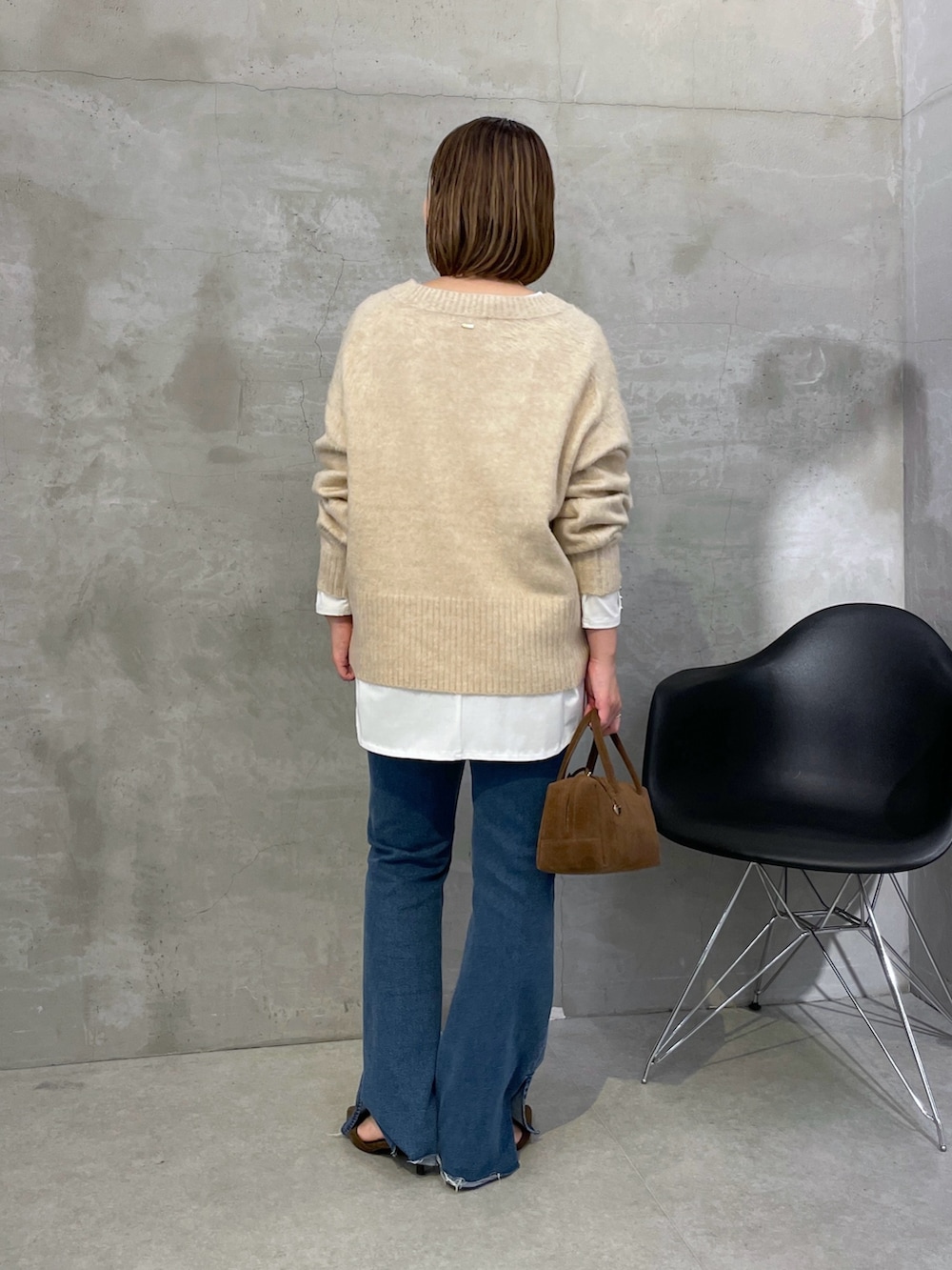 ベージュ系のニット/セーター、ブルー系のデニムパンツ、ブラウン系のバッグを着用したレディースの秋コーディネートの2枚目の写真