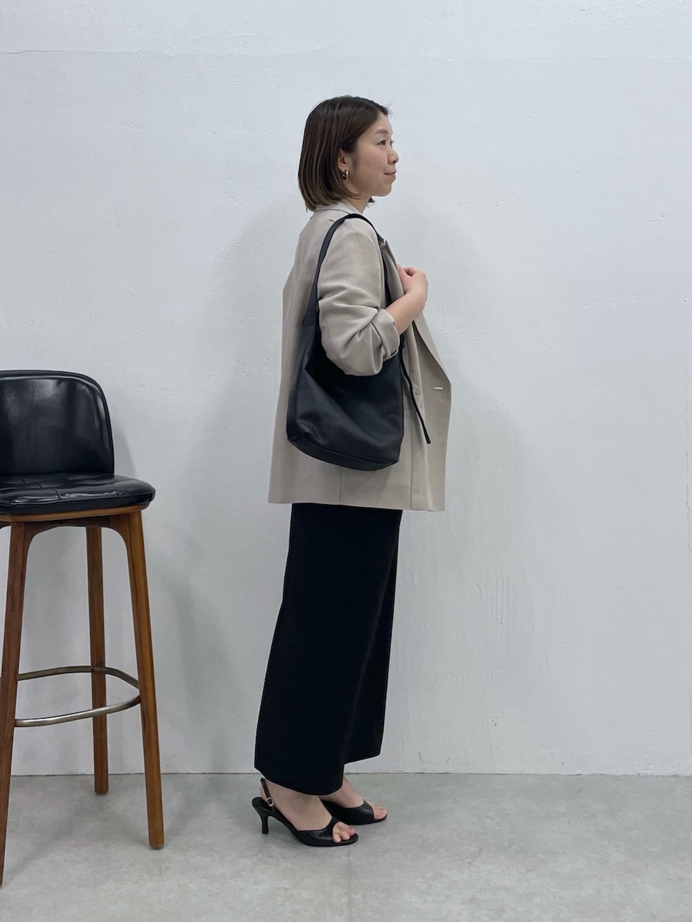 ブラック系のスカート、ベージュ系のテーラードジャケット、ホワイト系のシャツ/ブラウスを着用したレディースの春コーディネートの6枚目の写真