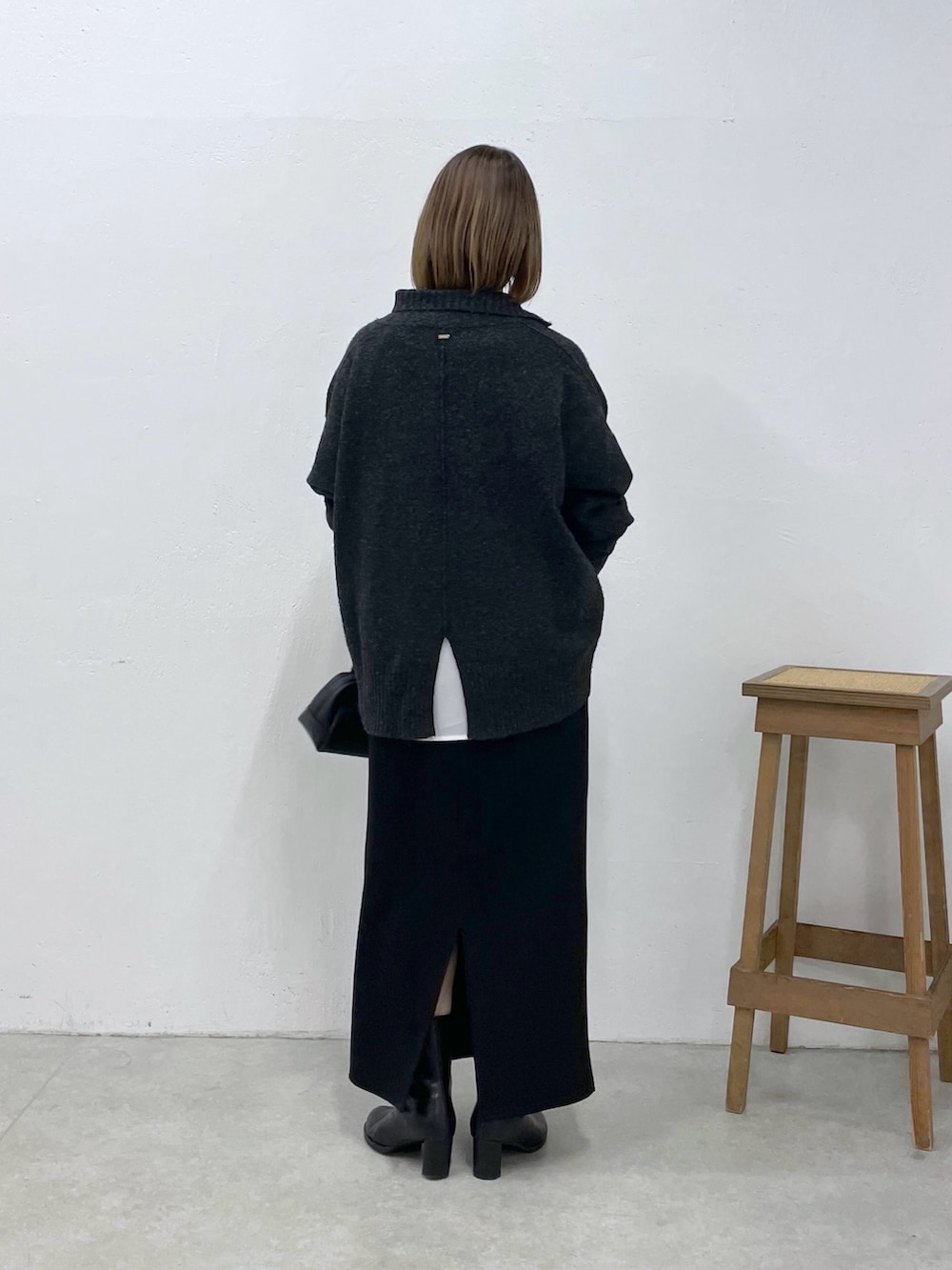 グレー系のニット/セーター、ホワイト系のシャツ/ブラウス、ブラック系のスカートを着用したレディースの冬コーディネートの3枚目の写真