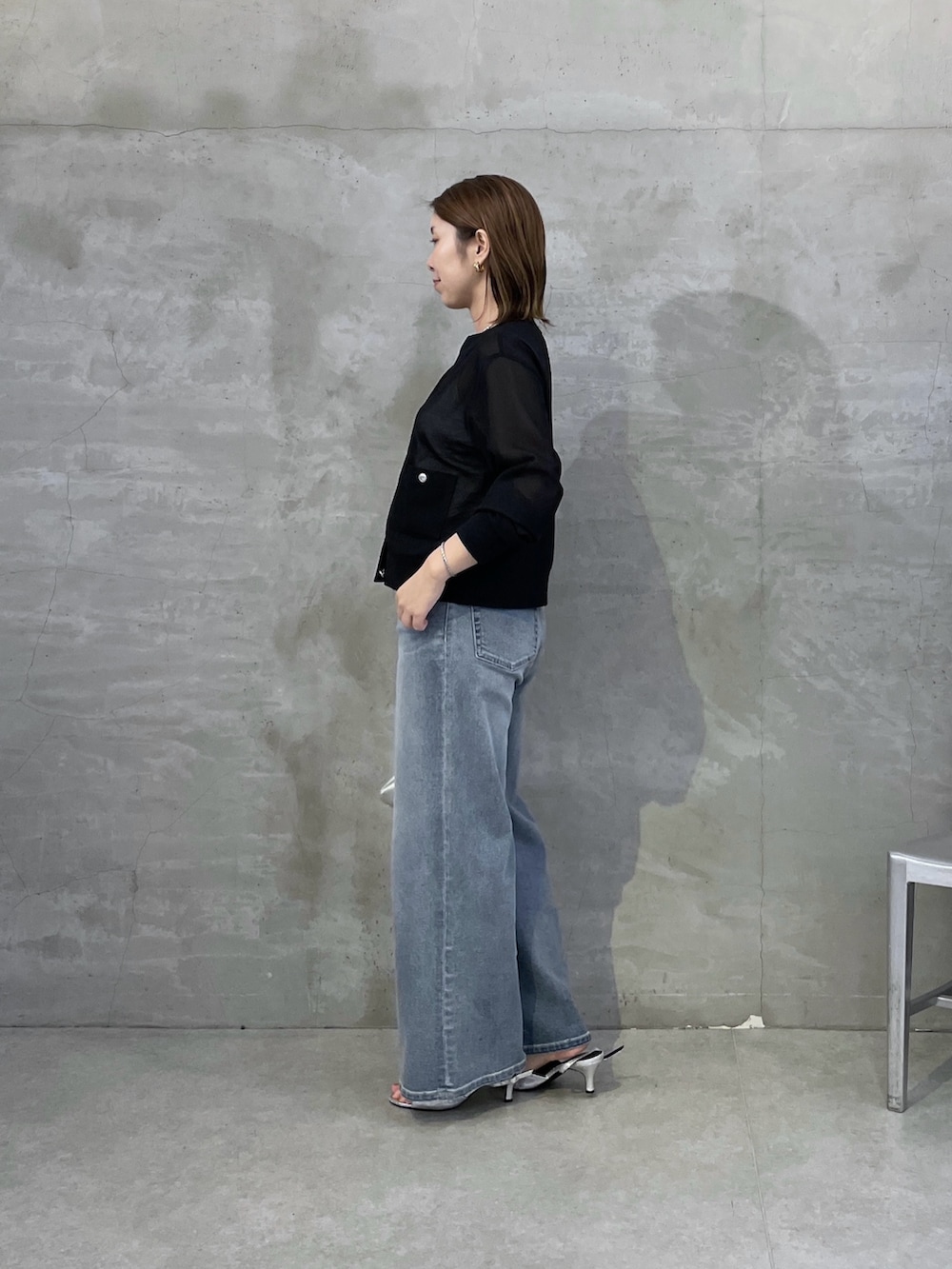 ブルー系のデニムパンツ、ブラック系のカーディガン/ボレロ、シルバー系のネックレスを着用したレディースの春コーディネートの2枚目の写真
