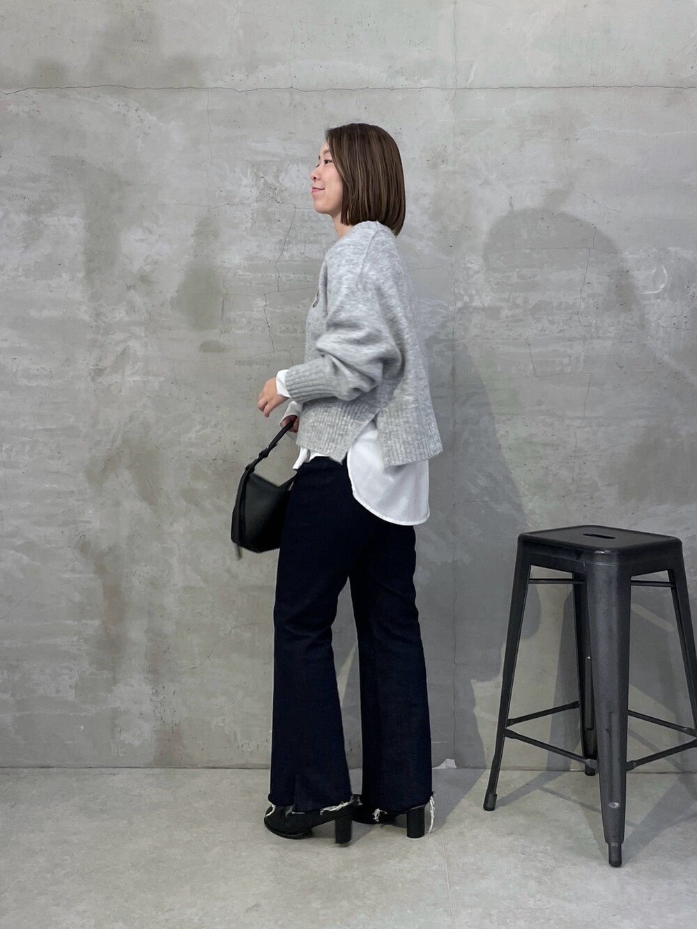 ホワイト系のシャツ/ブラウス、ブルー系のデニムパンツ、グレー系のニット/セーターを着用したレディースの秋コーディネートの2枚目の写真