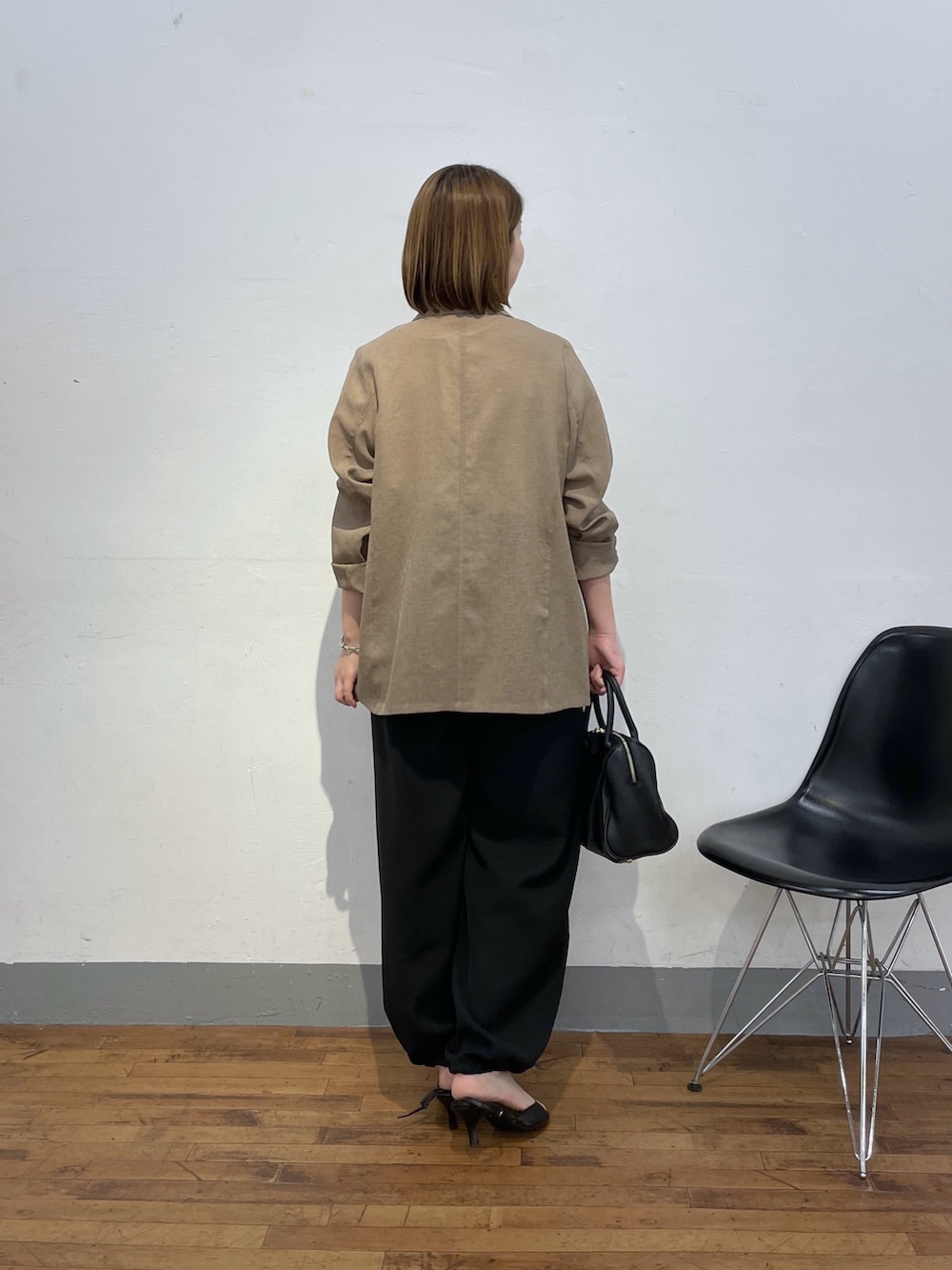 ベージュ系のテーラードジャケット、ホワイト系のTシャツ/カットソー、ブラック系のボストンバッグを着用したレディースの夏コーディネートの3枚目の写真