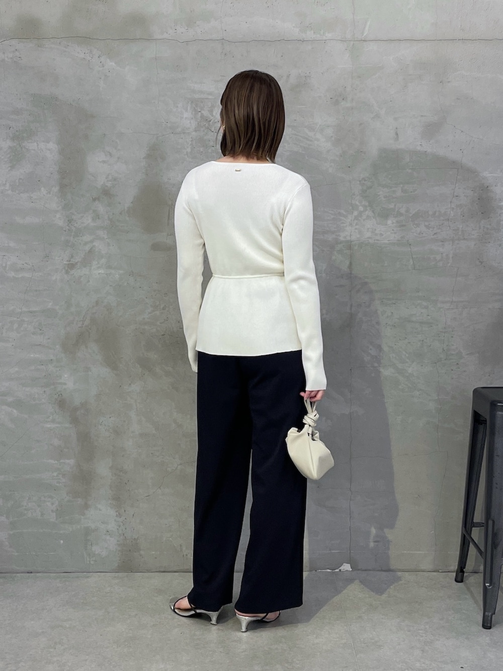 ブルー系のスラックス、ホワイト系のカーディガン/ボレロ、ゴールド系のネックレスを着用したレディースの春コーディネートの3枚目の写真