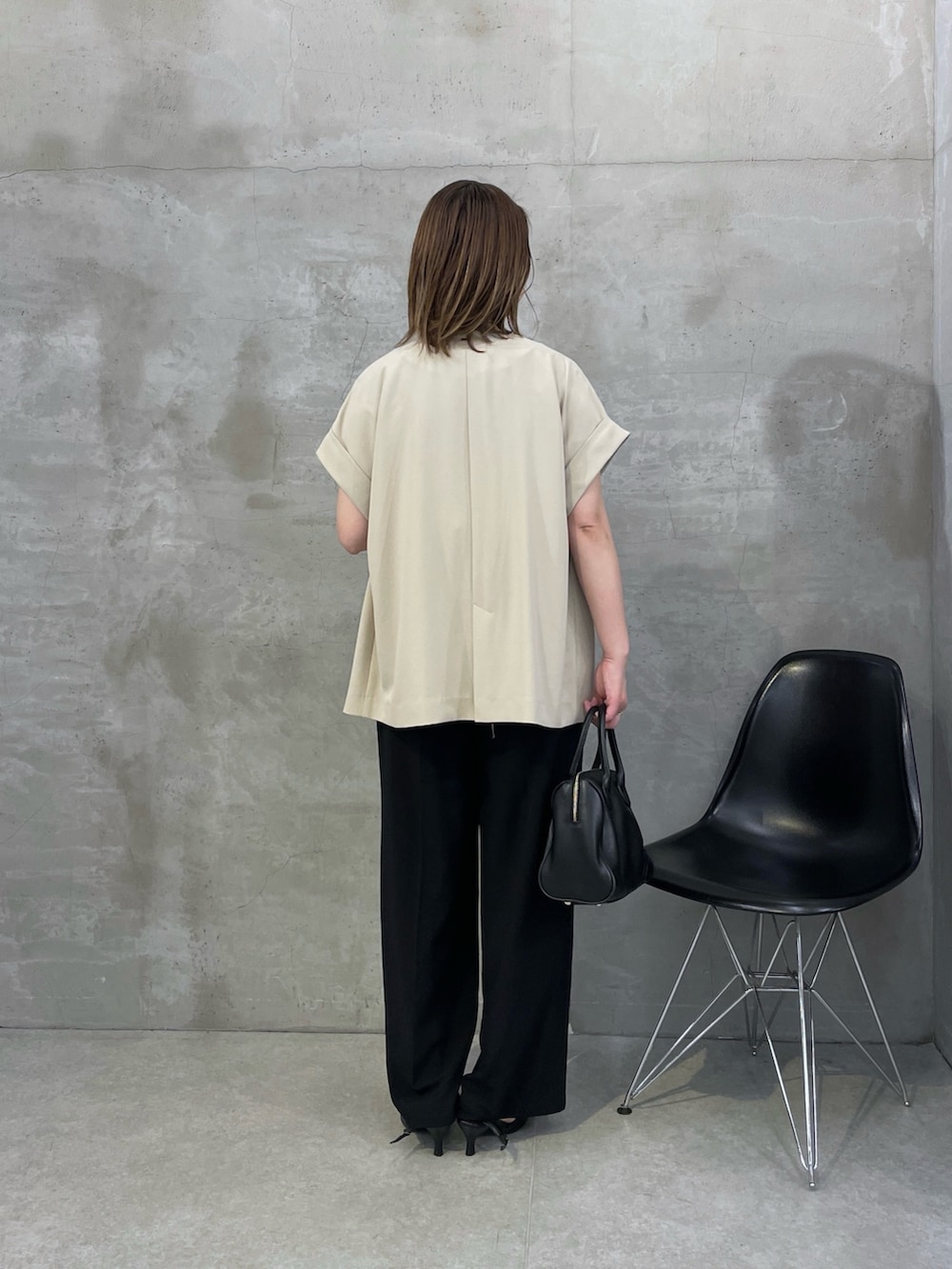 ベージュ系のテーラードジャケット、ホワイト系のTシャツ/カットソー、ブラック系のスラックスを着用したレディースの春コーディネートの2枚目の写真