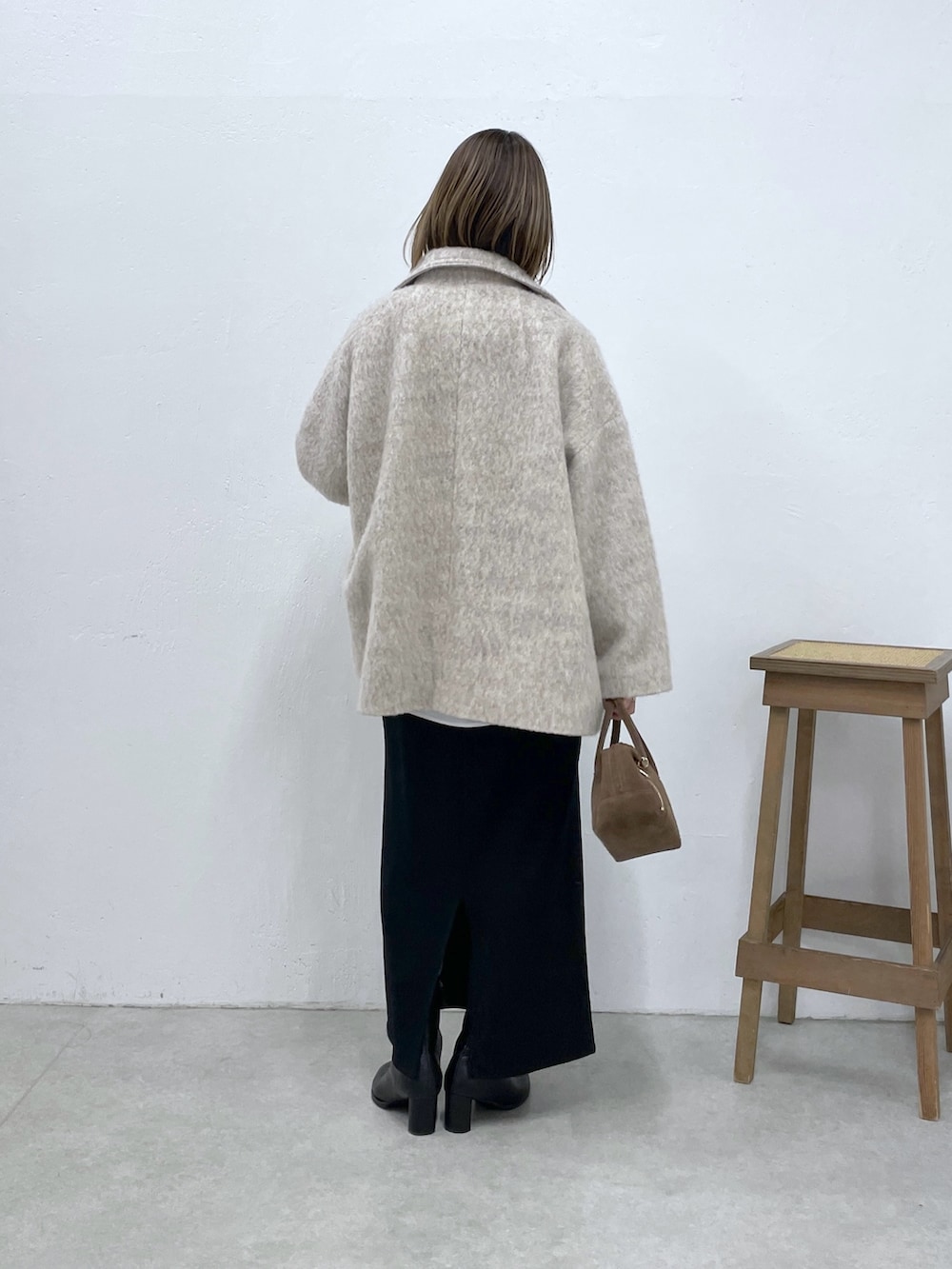 ベージュ系のその他アウター、ブラック系のスカート、ブラウン系のニット/セーターを着用したレディースの冬コーディネートの3枚目の写真