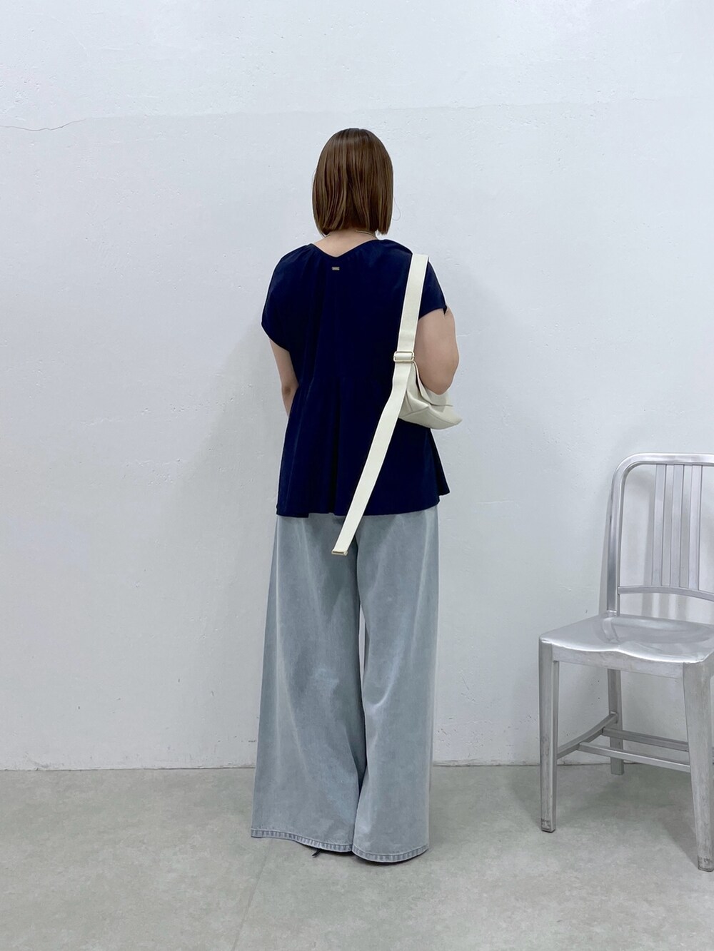 ブルー系のTシャツ/カットソー、ブルー系のデニムパンツ、ホワイト系のショルダーバッグを着用したレディースの夏コーディネートの3枚目の写真