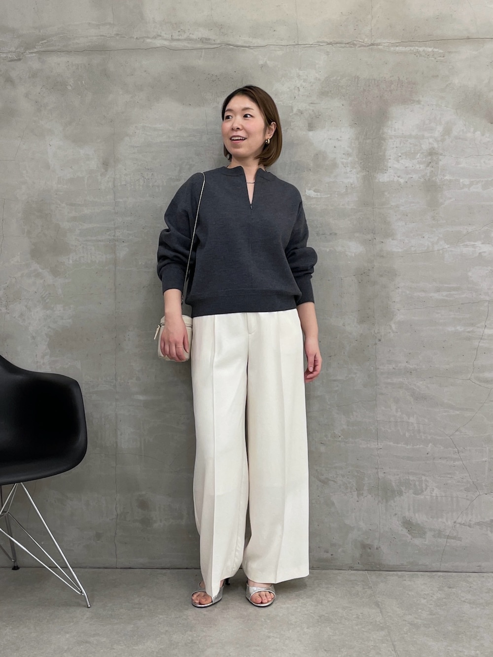 グレー系のニット/セーター、ホワイト系のスラックス、ホワイト系のショルダーバッグを着用したレディースの冬コーディネートの5枚目の写真