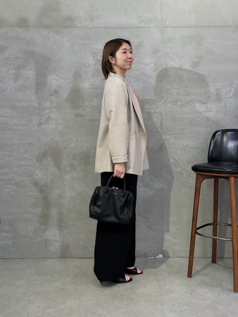 ベージュ系のテーラードジャケット、ホワイト系のシャツ/ブラウス、ブラック系のスラックスを着用したレディースの春コーディネートの2枚目の写真