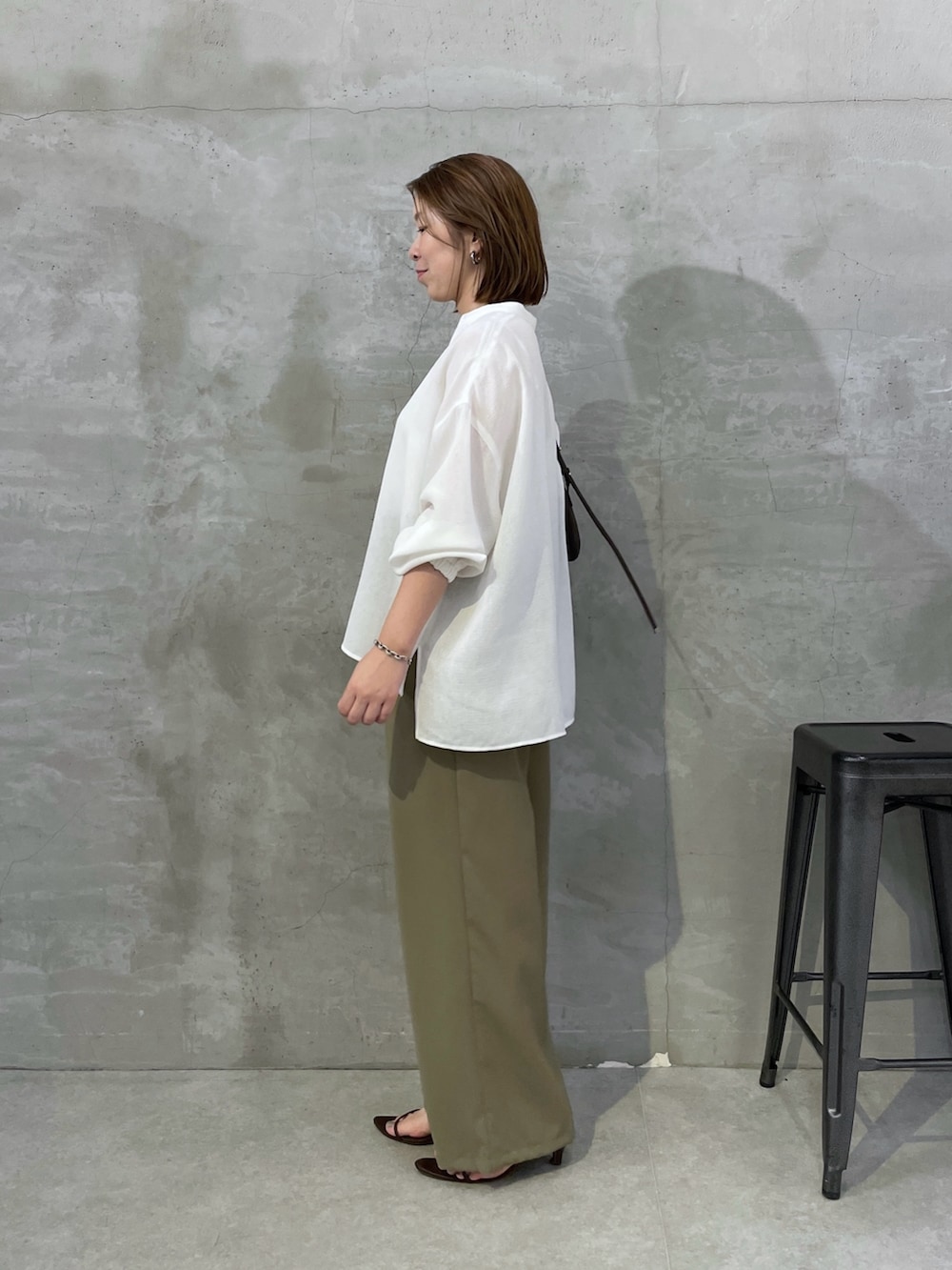 グリーン系のその他パンツ、ホワイト系のシャツ/ブラウス、ブラウン系のショルダーバッグを着用したレディースの夏コーディネートの2枚目の写真