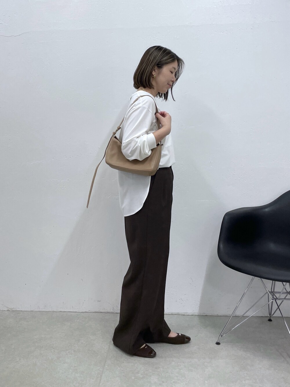 ホワイト系のTシャツ/カットソー、ブラウン系のスラックス、ベージュ系のショルダーバッグを着用したレディースの夏コーディネートの4枚目の写真