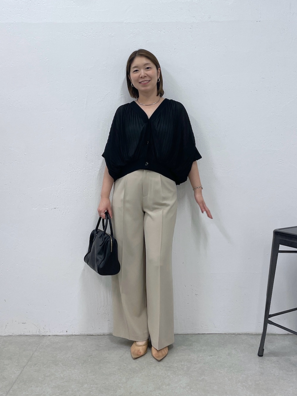 ブラック系のTシャツ/カットソー、ベージュ系のスラックス、ブラック系のボストンバッグを着用したレディースの夏コーディネートの4枚目の写真