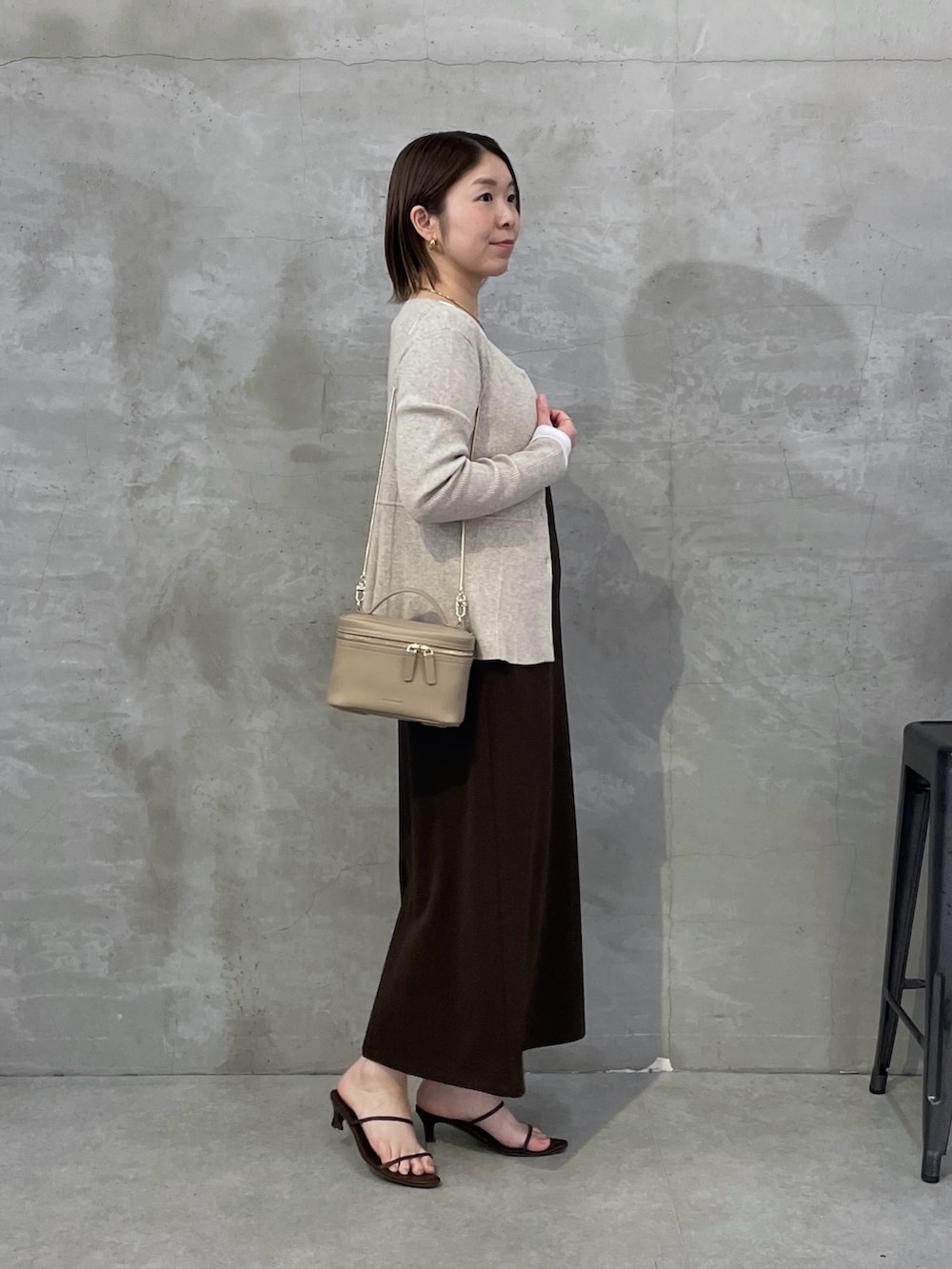 ベージュ系のカーディガン/ボレロ、ブラウン系のワンピース、ホワイト系のTシャツ/カットソーを着用したレディースの春コーディネートの2枚目の写真