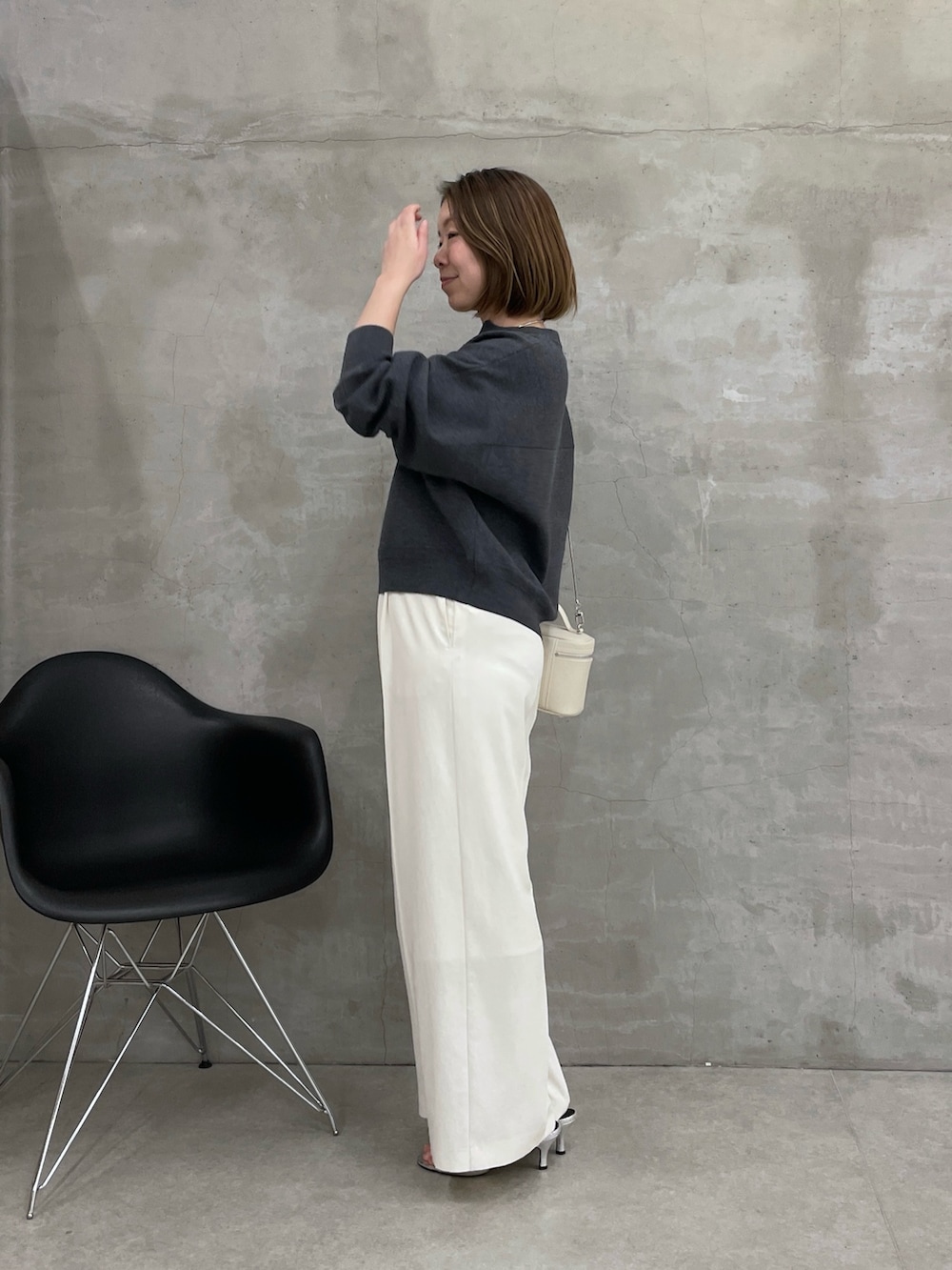 グレー系のニット/セーター、ホワイト系のスラックス、ホワイト系のショルダーバッグを着用したレディースの冬コーディネートの4枚目の写真