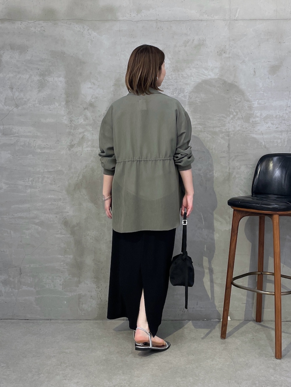 グリーン系のシャツ/ブラウス、ホワイト系のTシャツ/カットソー、ブラック系のスカートを着用したレディースの春コーディネートの3枚目の写真