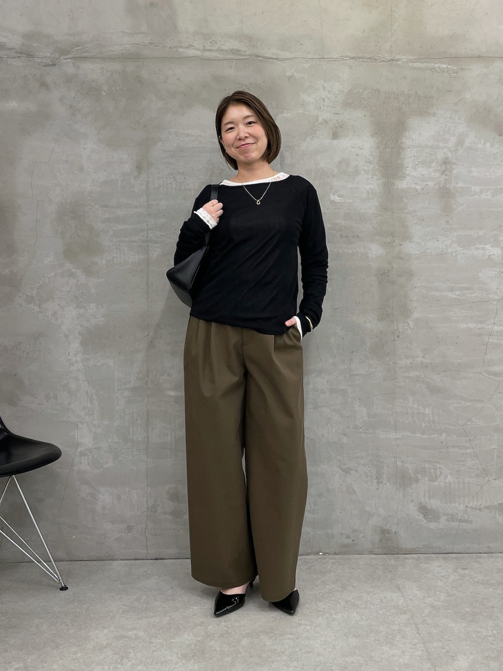 グリーン系のチノパンツ、ブラック系のTシャツ/カットソー、ホワイト系のTシャツ/カットソーを着用したレディースの冬コーディネートの4枚目の写真