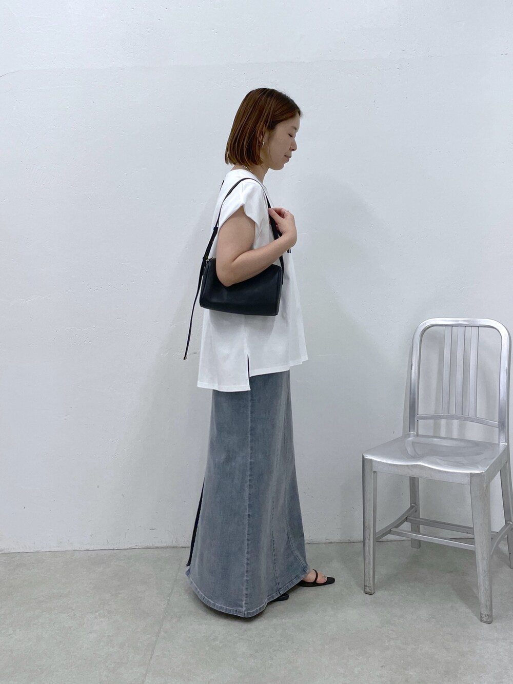ホワイト系のTシャツ/カットソー、ブルー系のスカート、ブラック系のショルダーバッグを着用したレディースの夏コーディネートの2枚目の写真