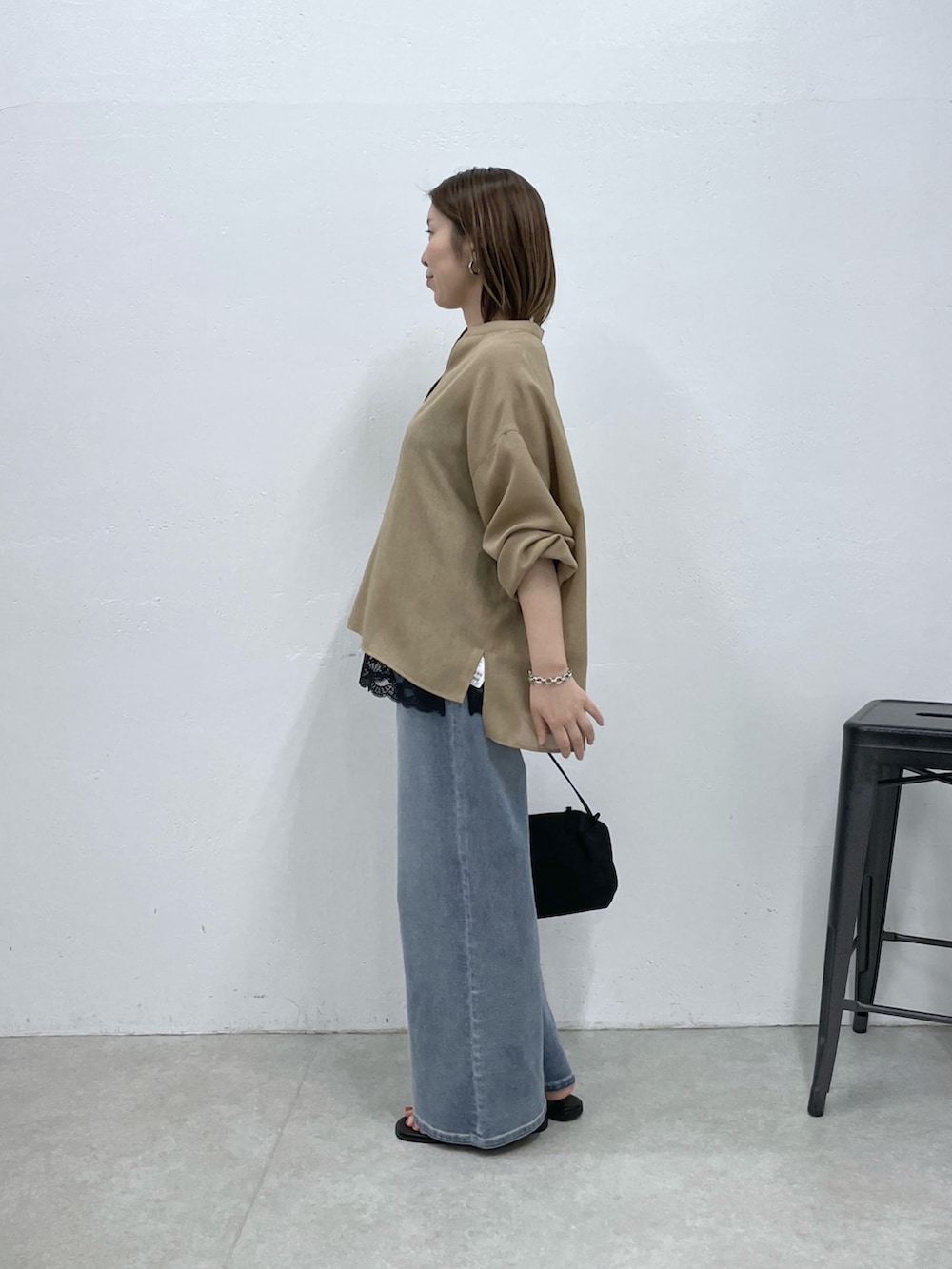 ベージュ系のシャツ/ブラウス、ブラック系のキャミソール、ブルー系のデニムパンツを着用したレディースの春コーディネートの2枚目の写真