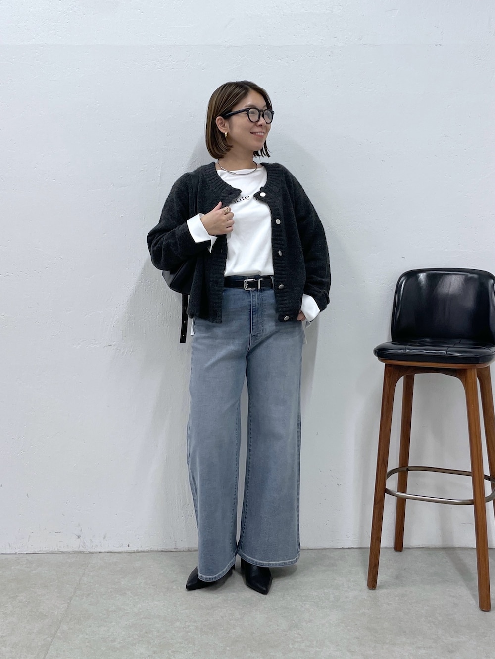 グレー系のカーディガン/ボレロ、ホワイト系のシャツ/ブラウス、ブルー系のデニムパンツを着用したレディースの秋コーディネートの4枚目の写真