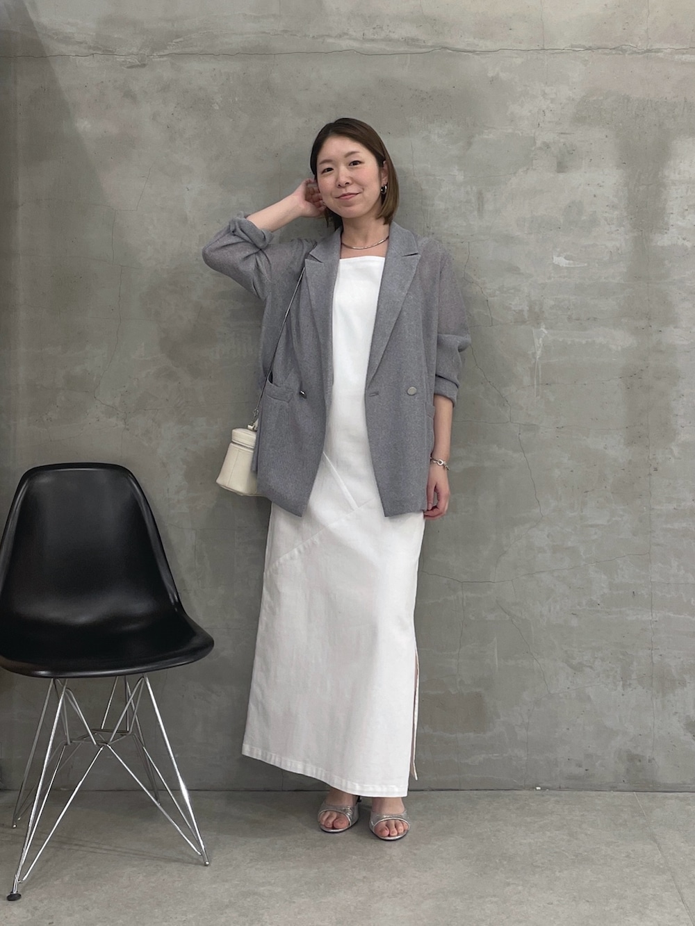グレー系のテーラードジャケット、ホワイト系のワンピース、ホワイト系のショルダーバッグを着用したレディースの春コーディネートの5枚目の写真