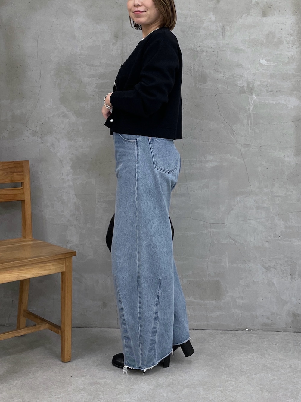 ブラック系のカーディガン/ボレロ、ブルー系のデニムパンツ、ホワイト系のTシャツ/カットソーを着用したレディースの冬コーディネートの4枚目の写真