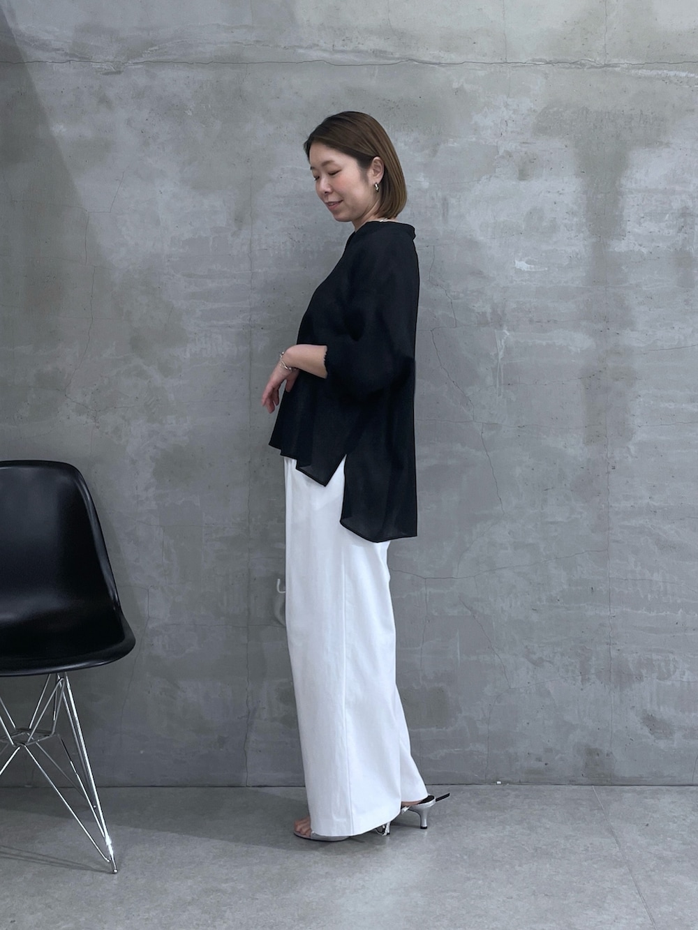 ブラック系のシャツ/ブラウス、ホワイト系のスラックスを着用したレディースの春コーディネートの2枚目の写真
