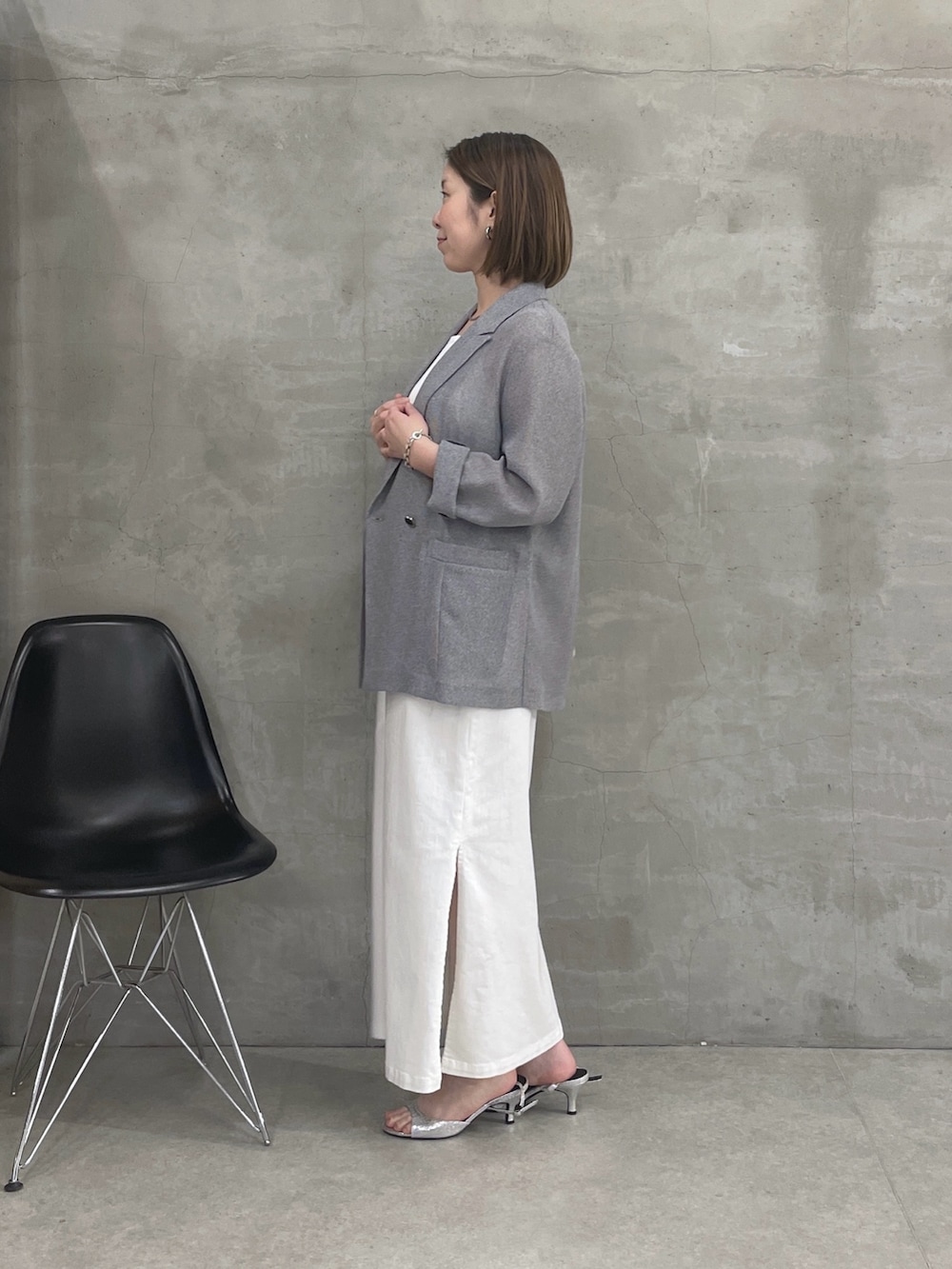 グレー系のテーラードジャケット、ホワイト系のワンピース、ホワイト系のショルダーバッグを着用したレディースの春コーディネートの2枚目の写真