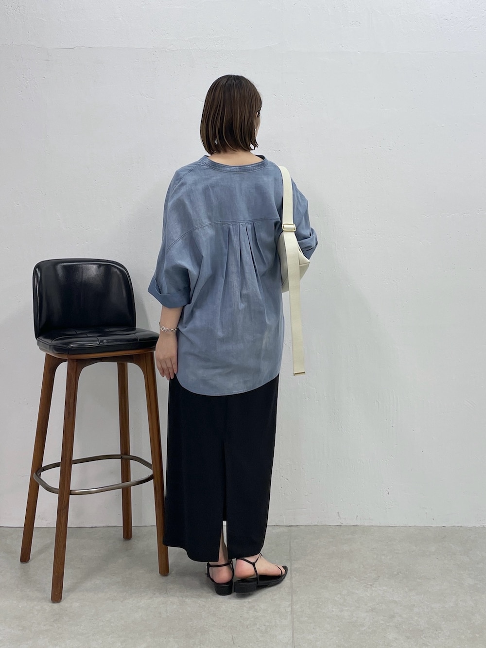 ブルー系のシャツ/ブラウス、ホワイト系のタンクトップ、ブラック系のスカートを着用したレディースの春コーディネートの2枚目の写真