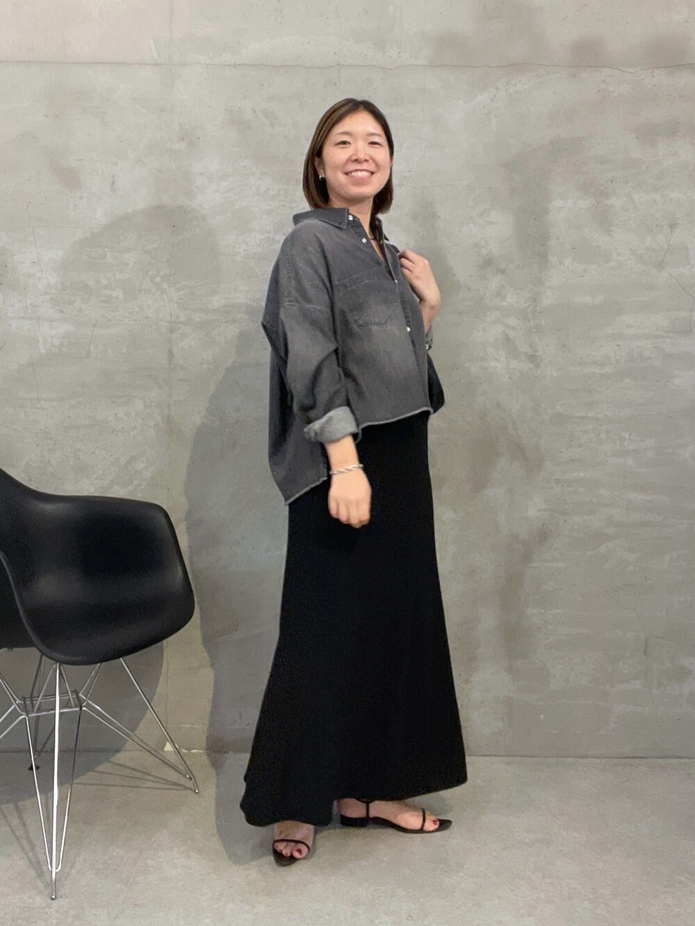 ブラック系のスカート、ブラック系のシャツ/ブラウス、ホワイト系のショルダーバッグを着用したレディースの夏コーディネートの4枚目の写真