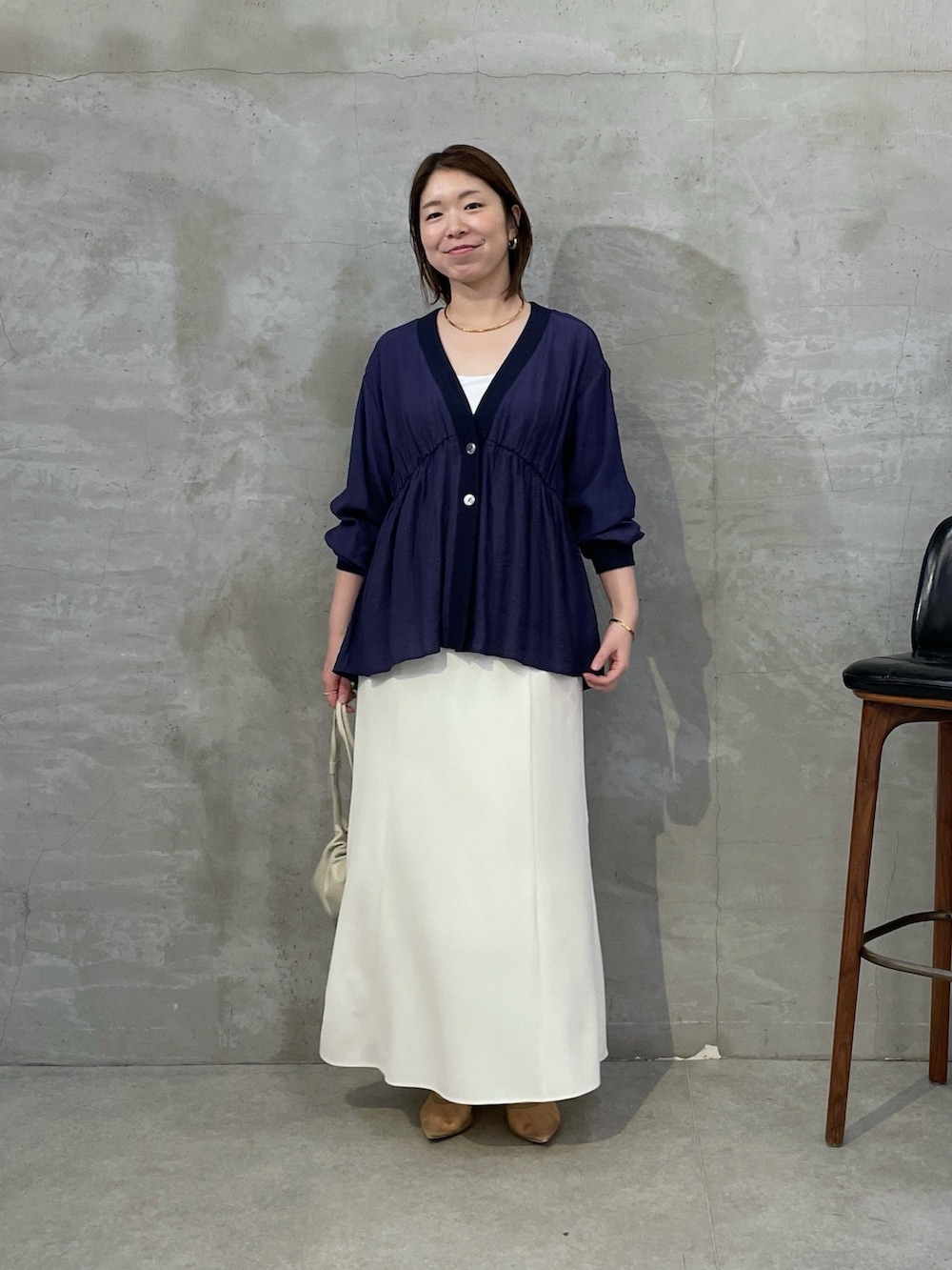 ブルー系のシャツ/ブラウス、ホワイト系のスカート、ホワイト系のショルダーバッグを着用したレディースの春コーディネートの6枚目の写真