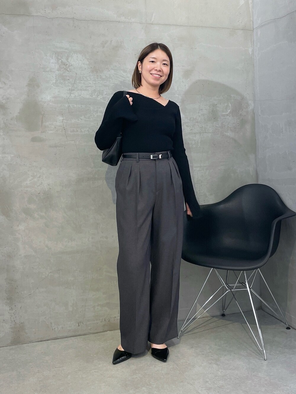 グレー系のスラックス、ブラック系のニット/セーター、シルバー系のネックレスを着用したレディースの秋コーディネートの4枚目の写真