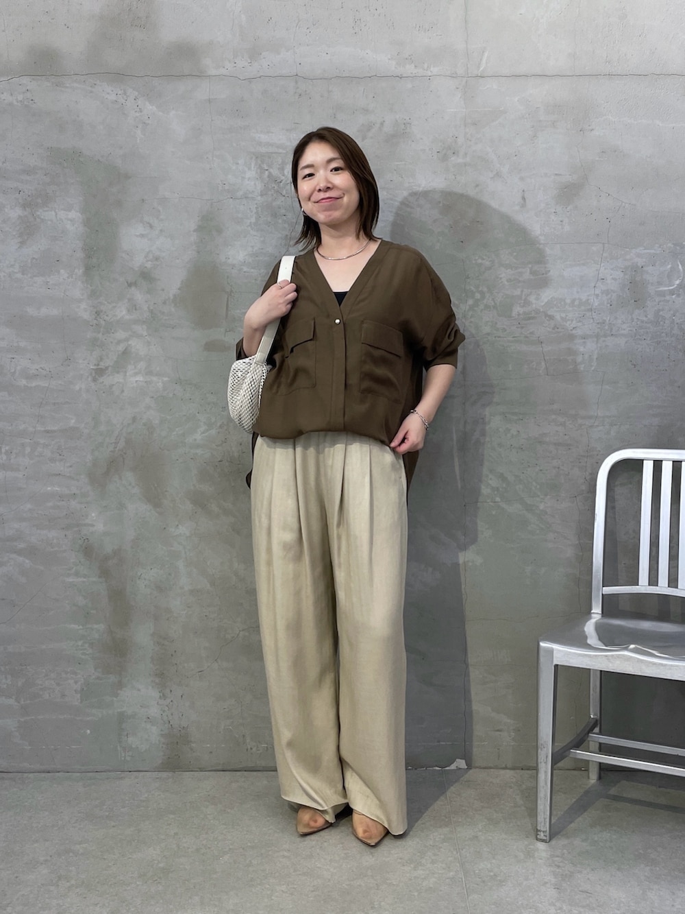 グリーン系のシャツ/ブラウス、ベージュ系のその他パンツ、ホワイト系のショルダーバッグを着用したレディースの夏コーディネートの4枚目の写真