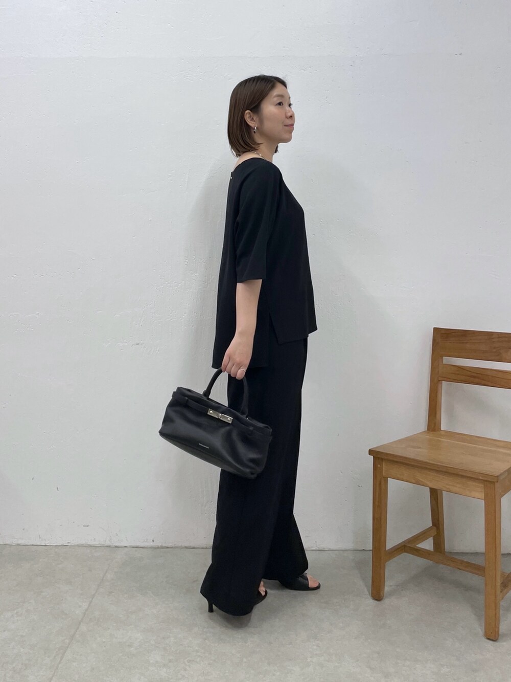 ブラック系のシャツ/ブラウス、ブラック系のスラックス、ブラック系のトートバッグを着用したレディースの春コーディネートの4枚目の写真