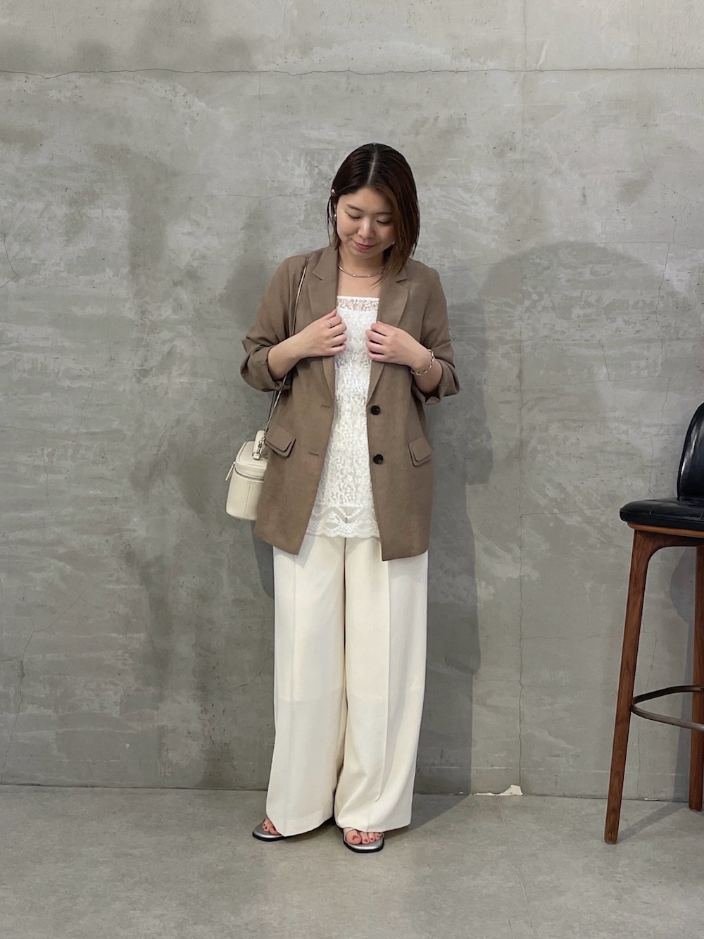 ベージュ系のテーラードジャケット、ホワイト系のキャミソール、ホワイト系のスラックスを着用したレディースの春コーディネートの4枚目の写真