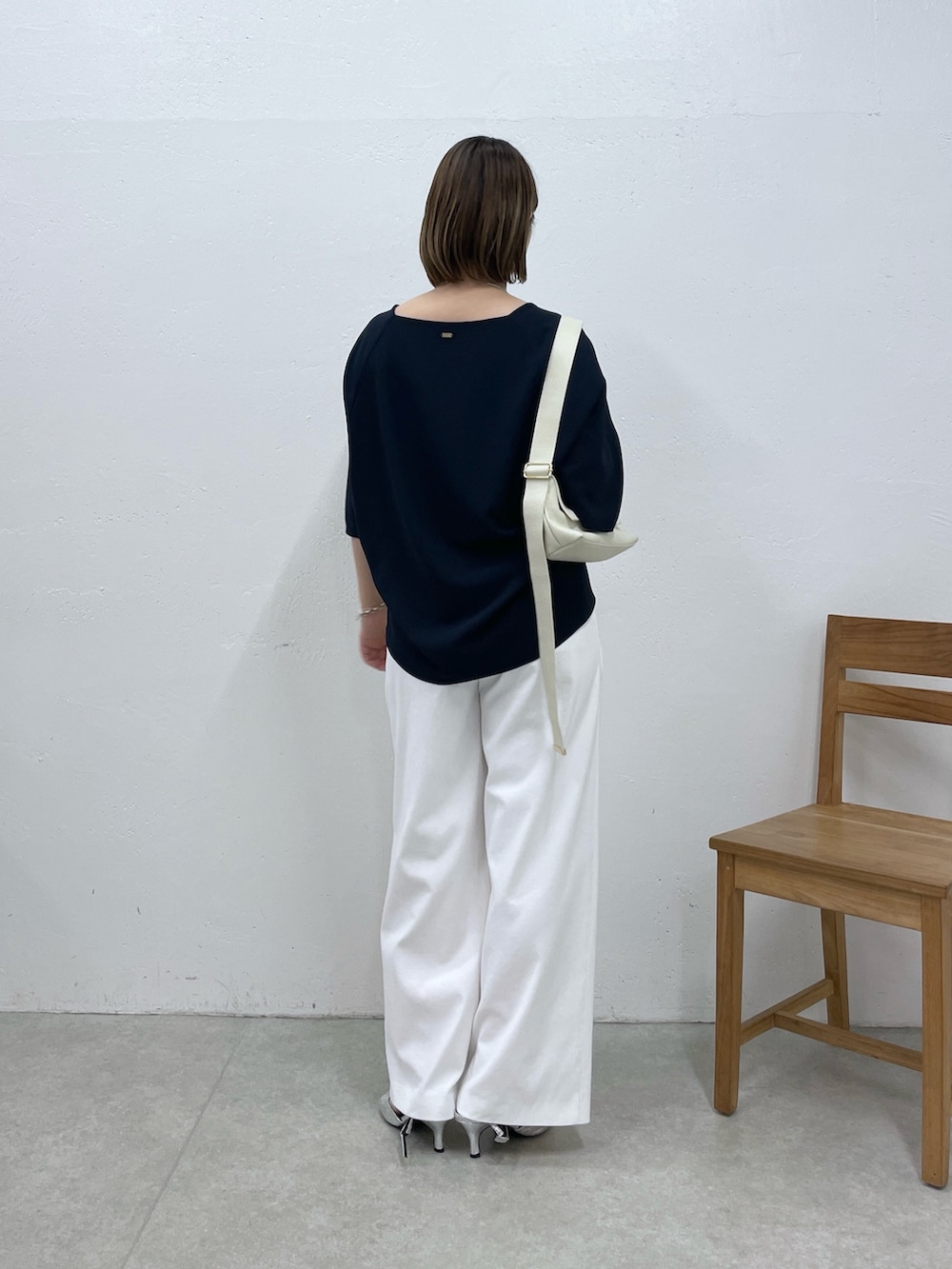 ブルー系のシャツ/ブラウス、ホワイト系のスラックス、ホワイト系のショルダーバッグを着用したレディースの春コーディネートの3枚目の写真