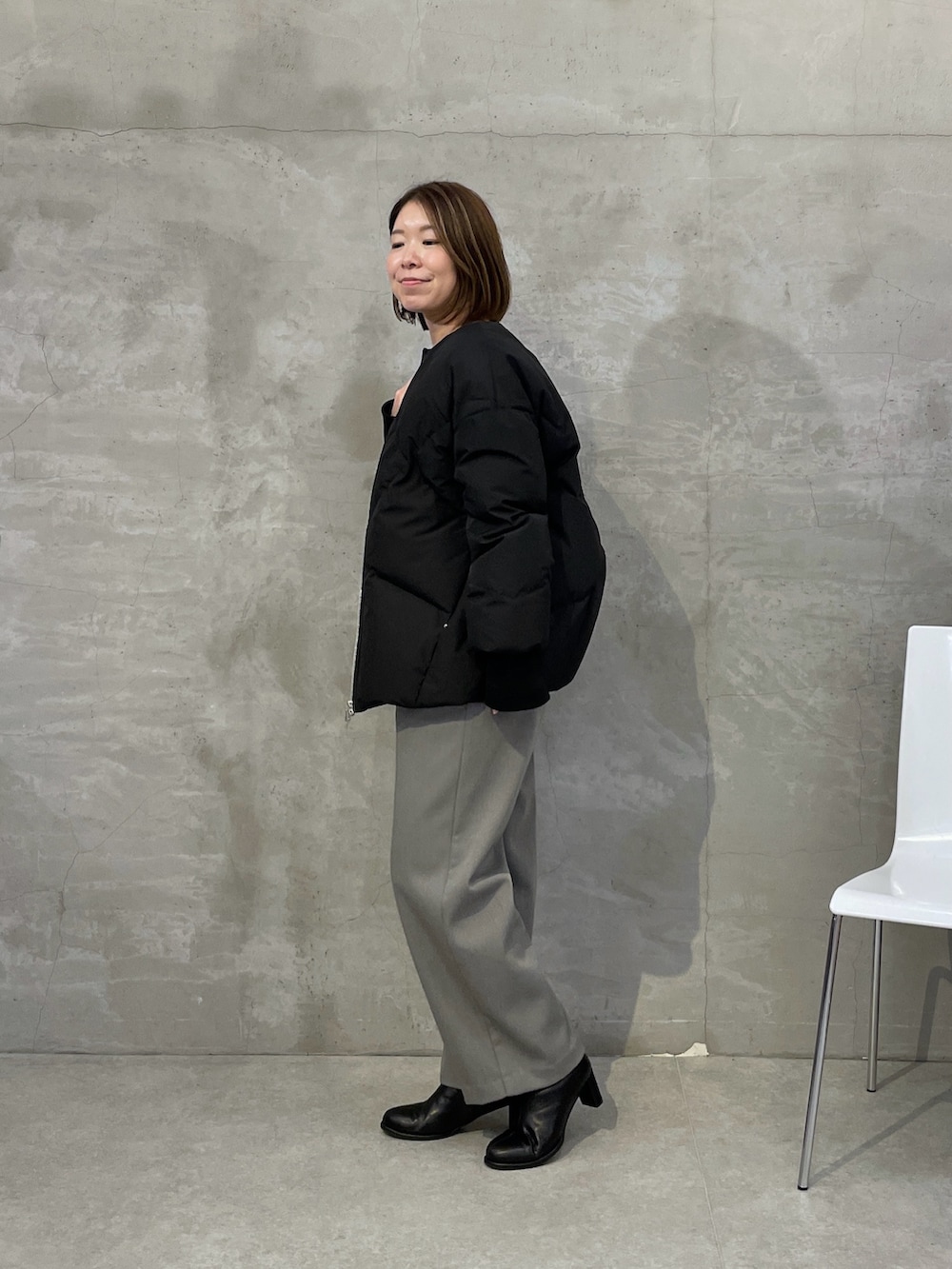 ブラック系のダウンジャケット/コート、グレー系のその他パンツ、ブラック系のニット/セーターを着用したレディースの秋コーディネートの3枚目の写真