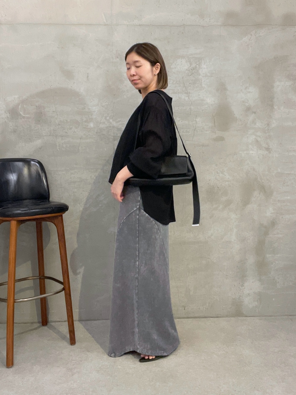 グレー系のスカート、ブラック系のシャツ/ブラウス、ブラック系のバッグを着用したレディースの夏コーディネートの3枚目の写真