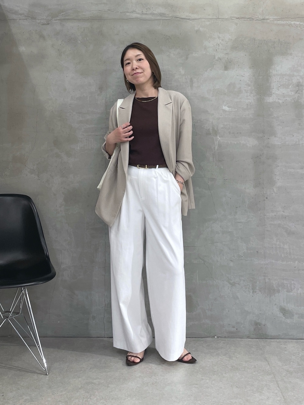 ベージュ系のテーラードジャケット、ブラウン系のTシャツ/カットソー、ホワイト系のスラックスを着用したレディースの春コーディネートの5枚目の写真
