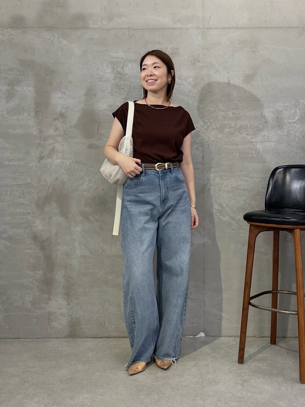 ブラウン系のTシャツ/カットソー、ブルー系のデニムパンツ、ホワイト系のショルダーバッグを着用したレディースの春コーディネートの5枚目の写真