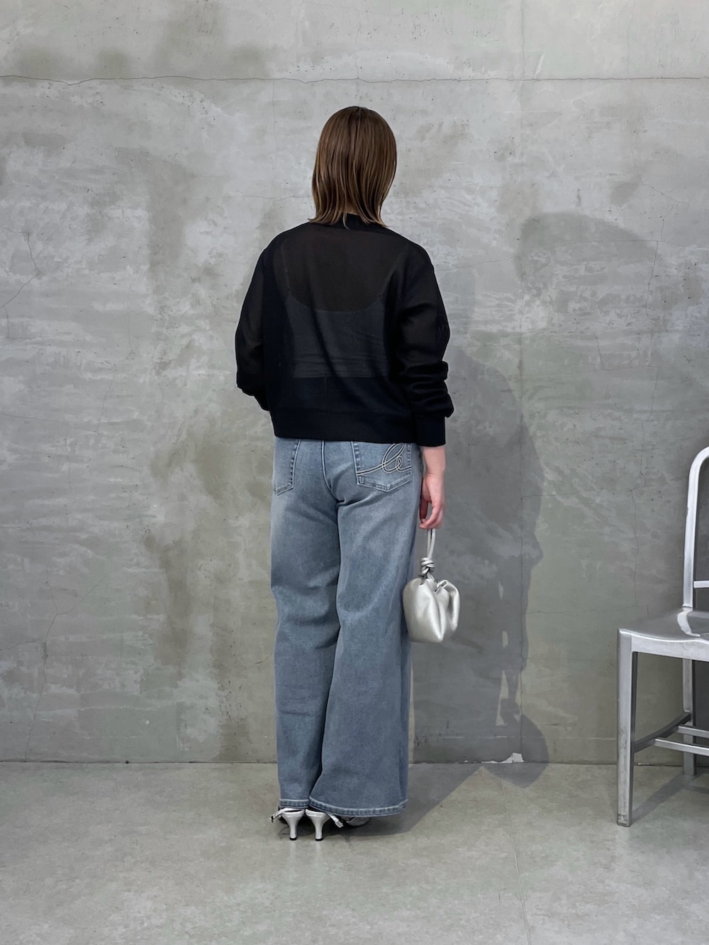 ブルー系のデニムパンツ、ブラック系のカーディガン/ボレロ、シルバー系のネックレスを着用したレディースの春コーディネートの3枚目の写真