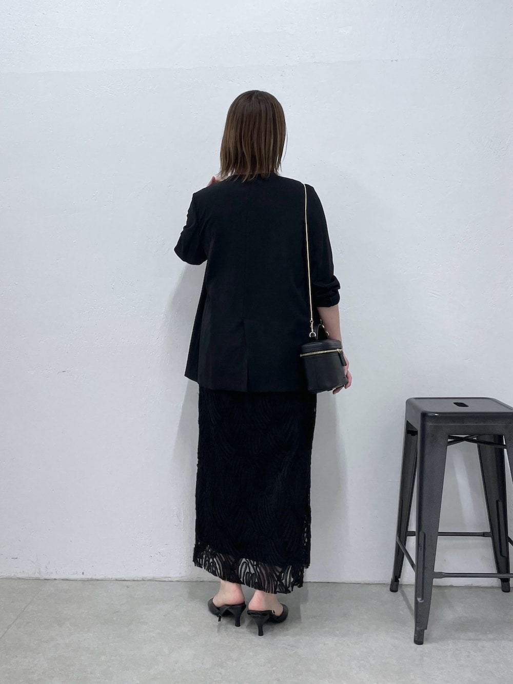 ブラック系のノーカラージャケット、ブラック系のワンピースを着用したレディースの春コーディネートの3枚目の写真