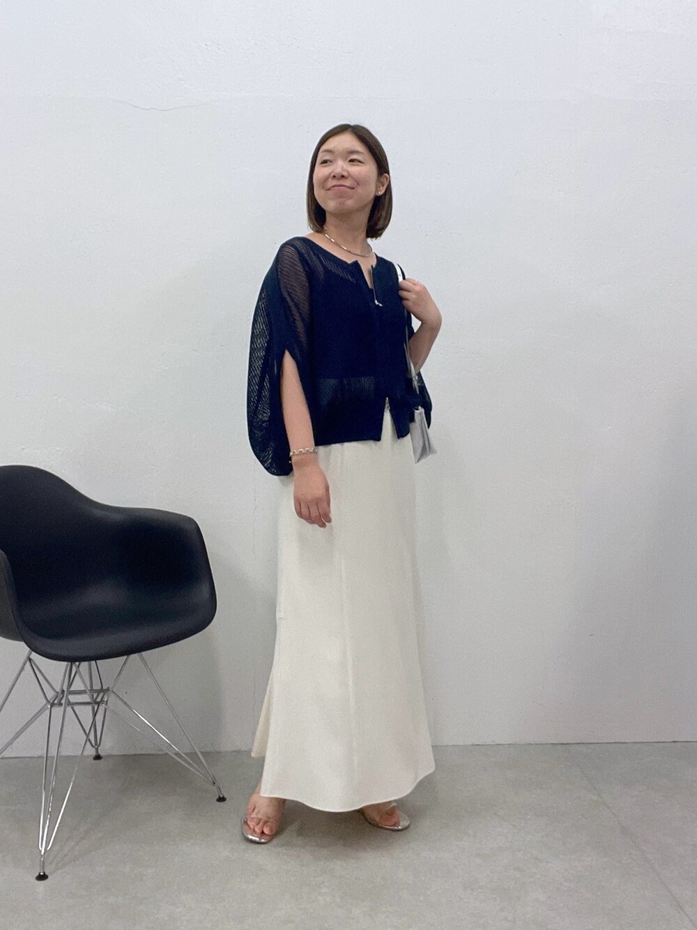 ホワイト系のスカート、ブルー系のカーディガン/ボレロ、シルバー系のショルダーバッグを着用したレディースの夏コーディネートの4枚目の写真