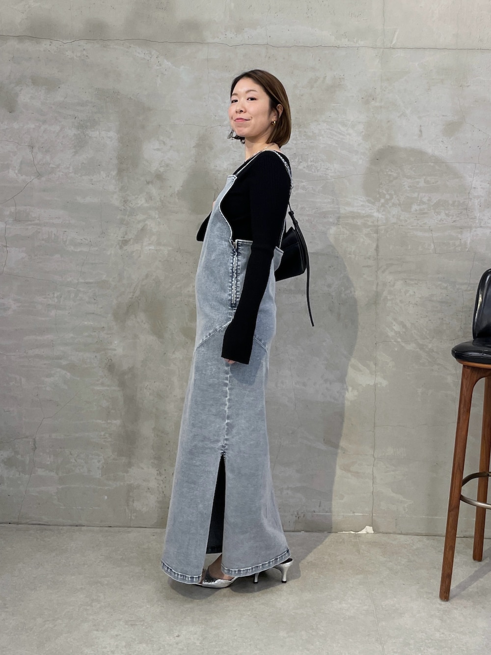 ブルー系のワンピース、ブラック系のニット/セーター、シルバー系のネックレスを着用したレディースの冬コーディネートの4枚目の写真